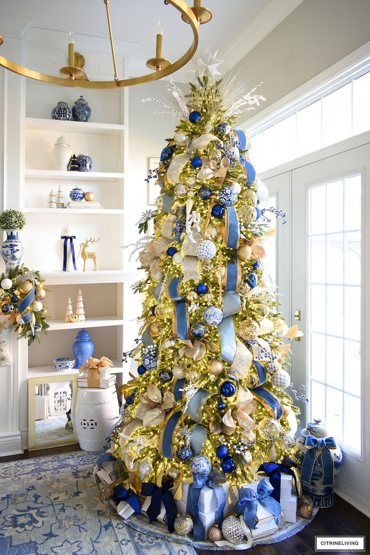 Gorgeous blue and gold decorated Christmas tree with white gift boxes tied with beautiful ribbons.