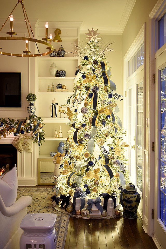 A stunning nighttime view of a blue and gold decorated Christmas tree.