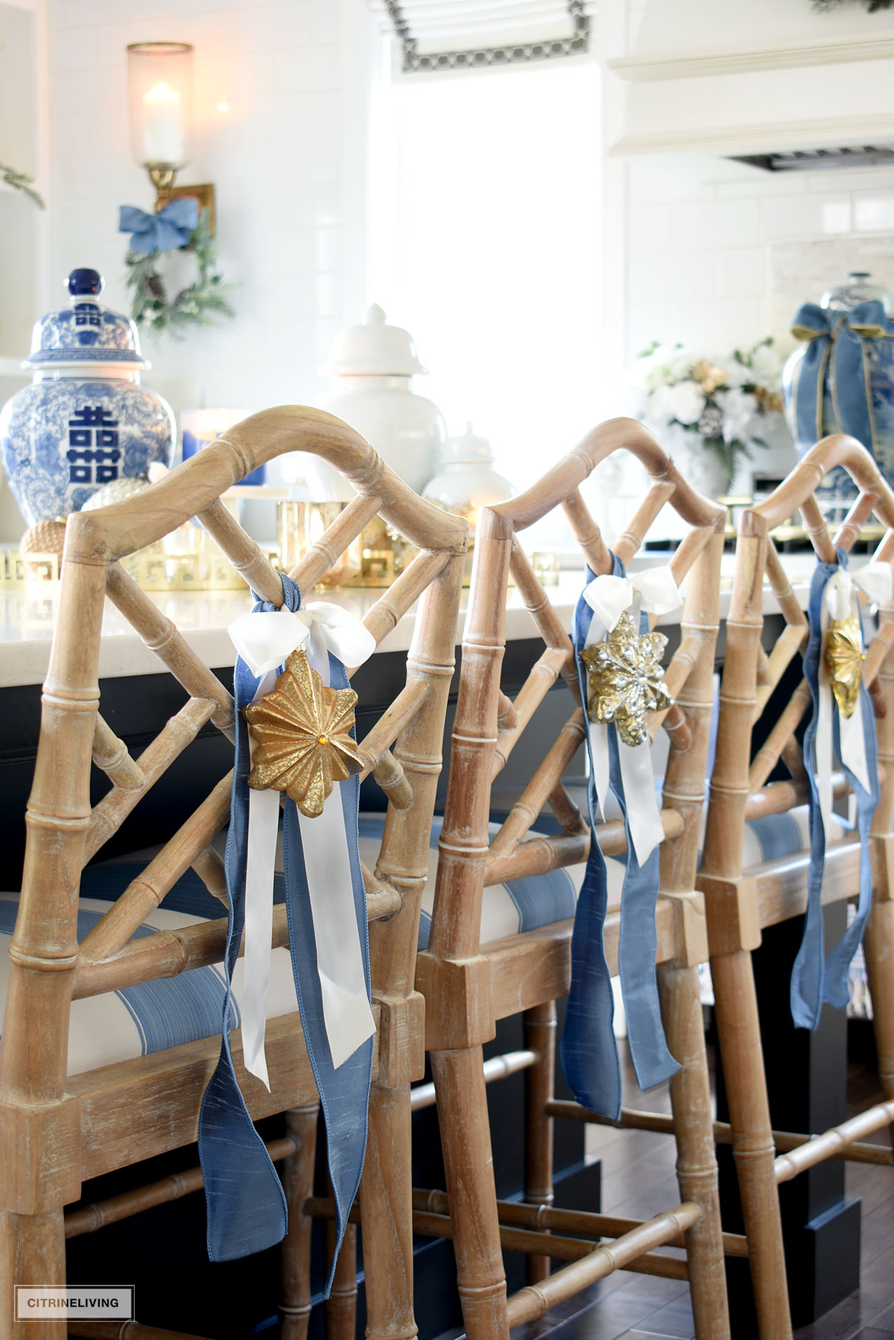 Blue and white ribbons tied with ornaments hang on the back of Chinese Chippendale wooden barstools.