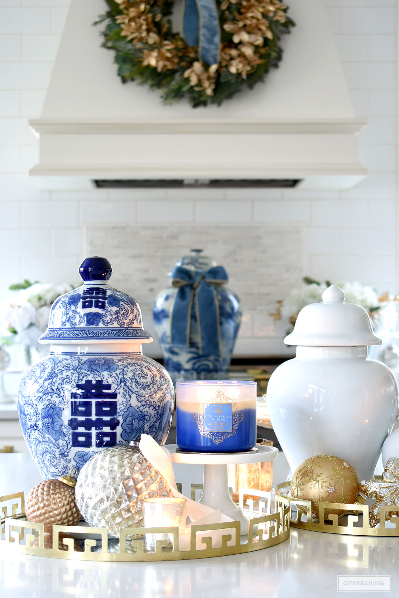 Ginger jars, candles and ornaments are displayed on chic gold trays for Christmas.