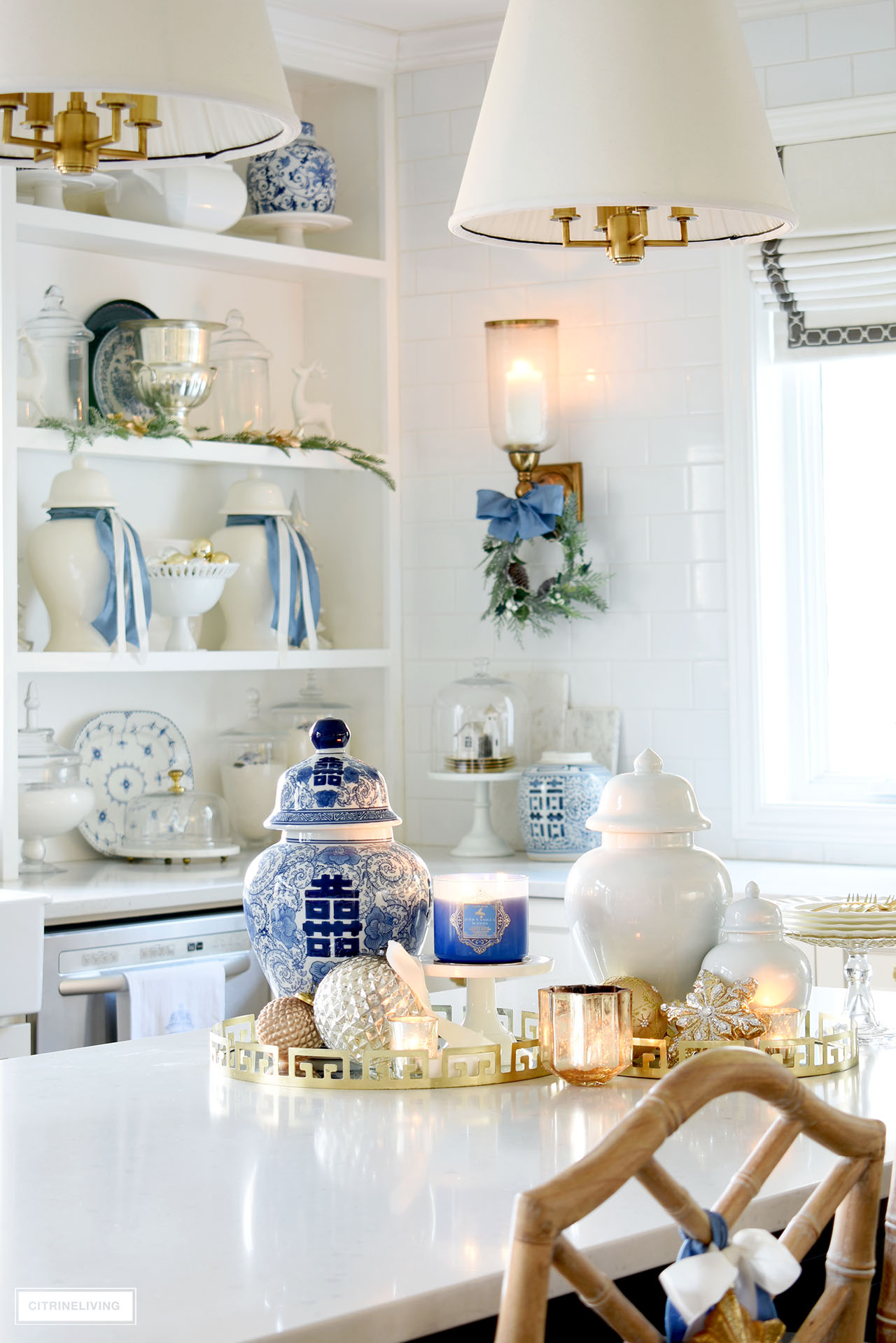 Kitchen island styled for Christmas with blue and white ginger jars, ornaments, candles and dishes.