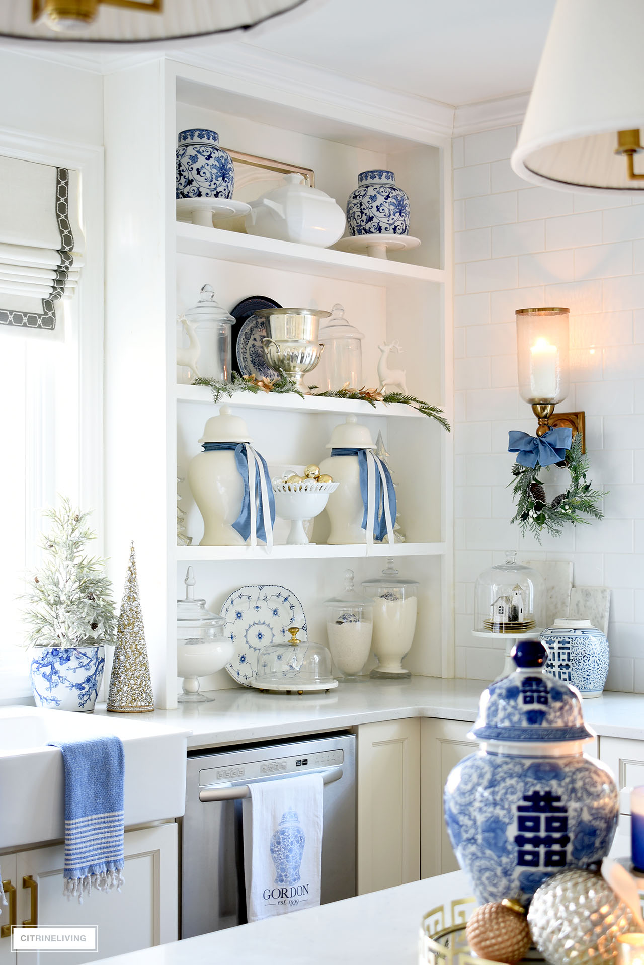 Kitchen shelves styled with ginger jars, blue and white accents and blue, white, green and gold Christmas touches.
