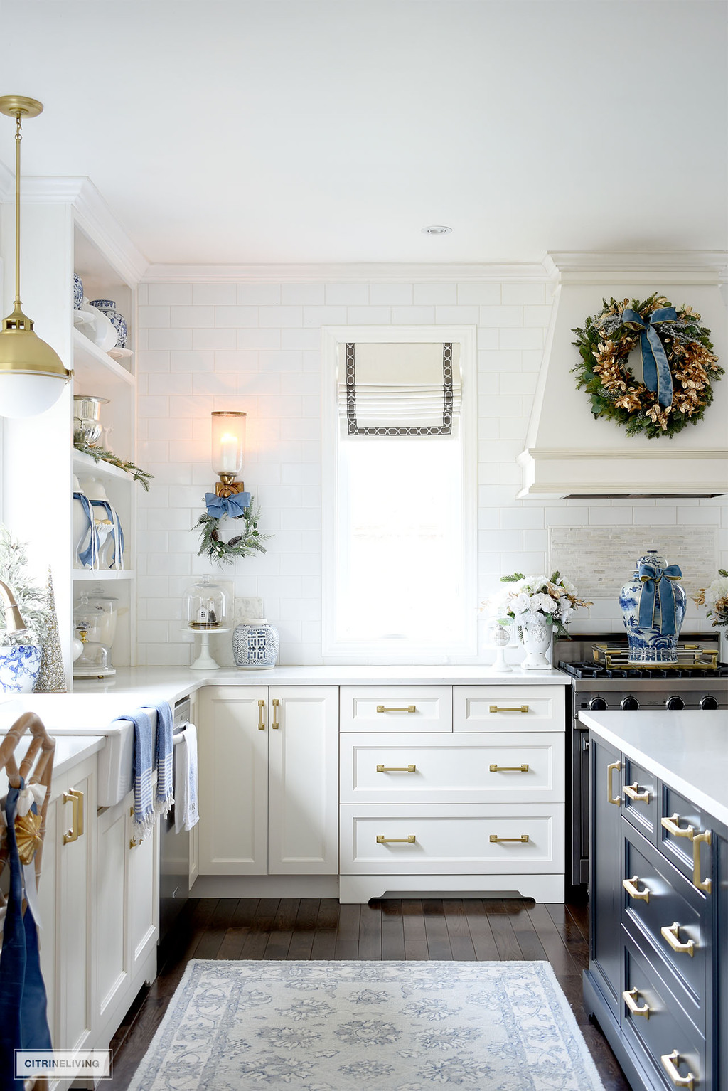 Beautiful and festive Christmas kitchen with blue and gold touches and green wreaths 
