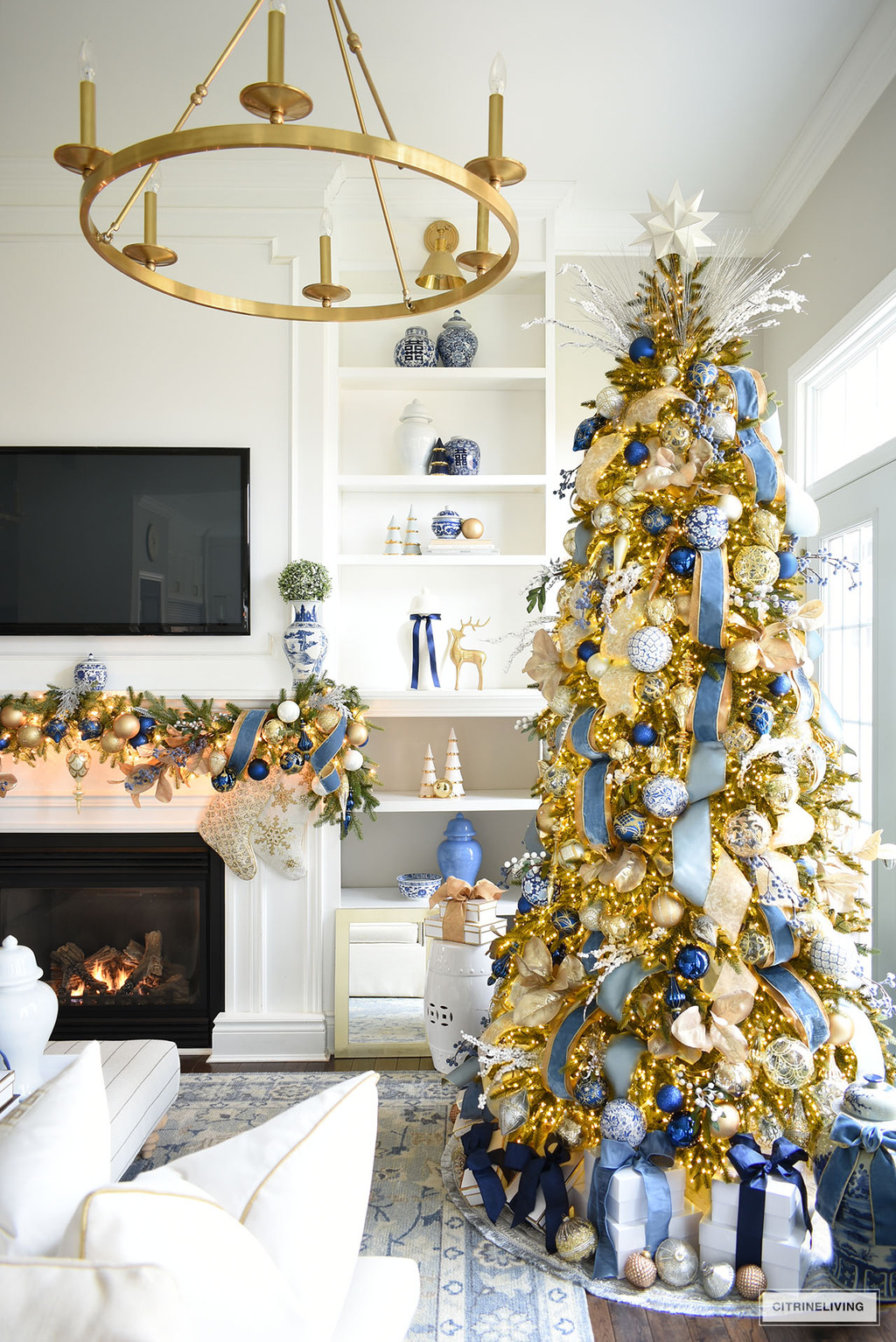 Elegant Christmas tree and garland with decorated with blue and gold ornaments and ribbon.