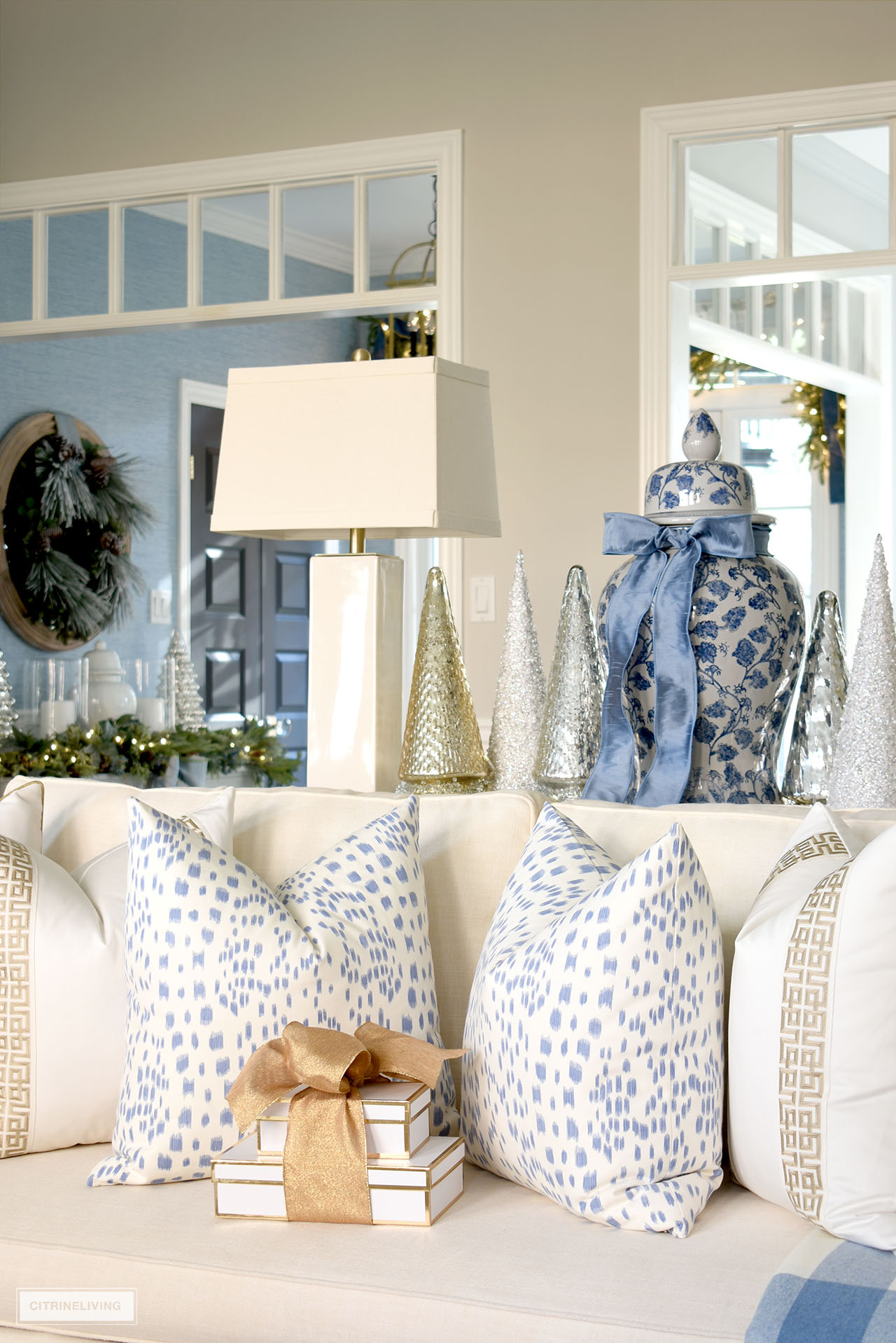Blue and white Le Touches pillows in medium blue with white and gold trimmed pillows.