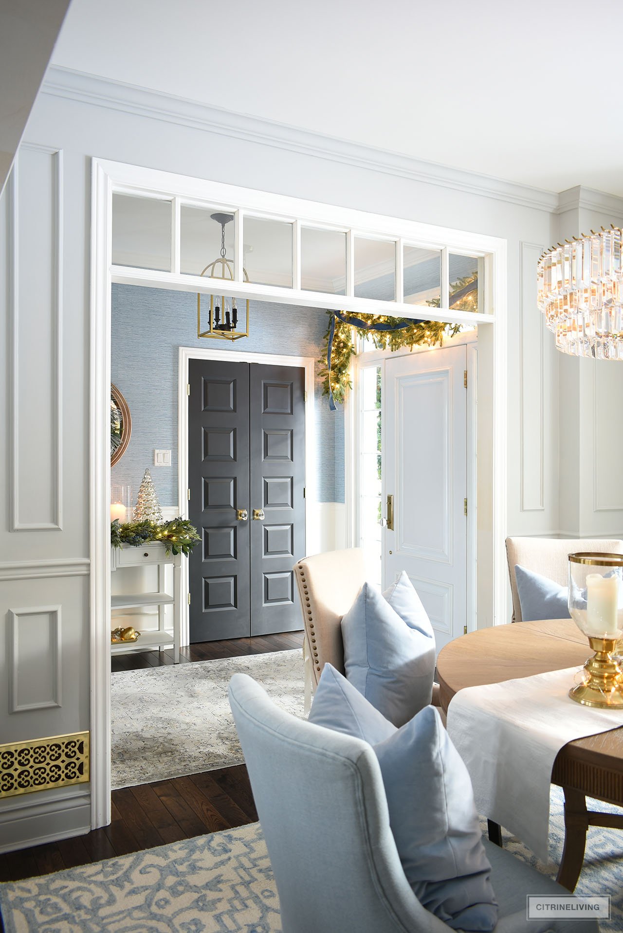 A view into a Christmas decorated entryway looking from the dining room.