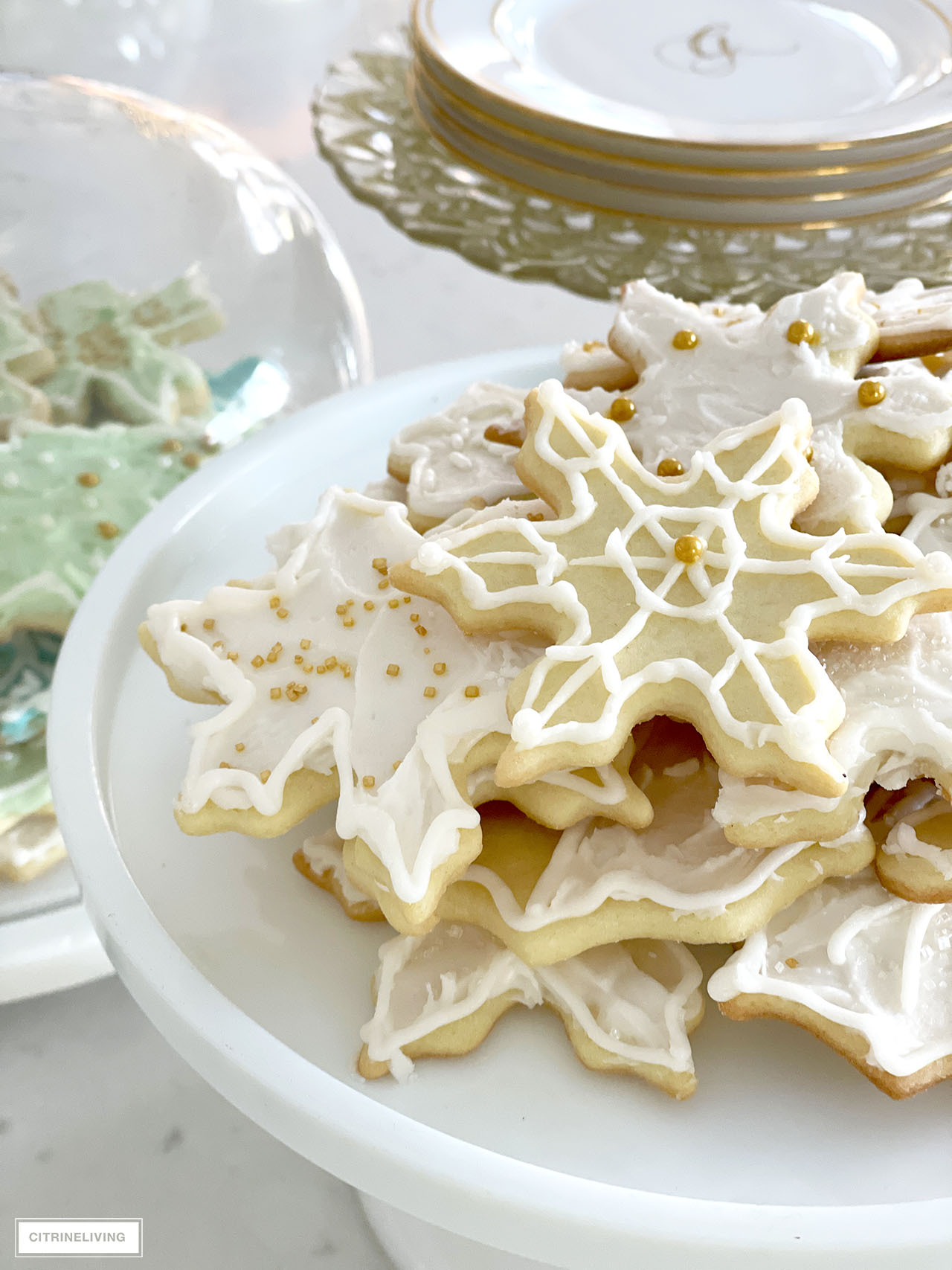 Details of pretty white frosted Christmas cookies decorated with gold sprinkles.
