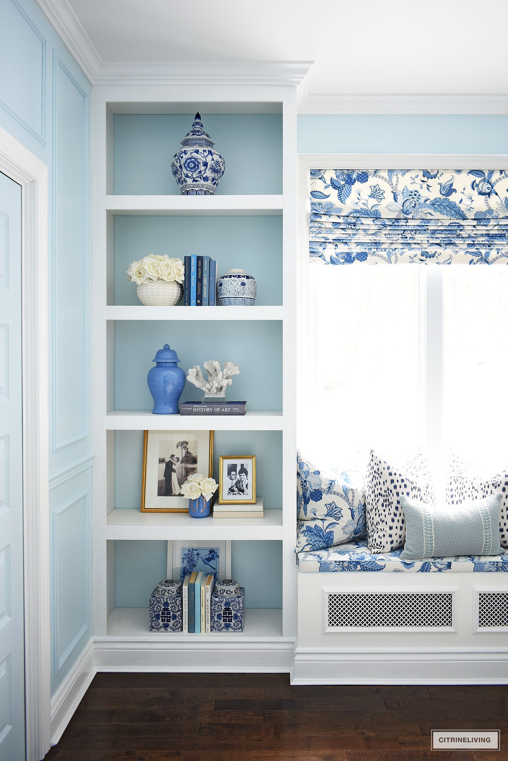 Blue and white decorated home office featuring a gorgeous window seat and builtin shelves decorated with timeless ginger jars.
