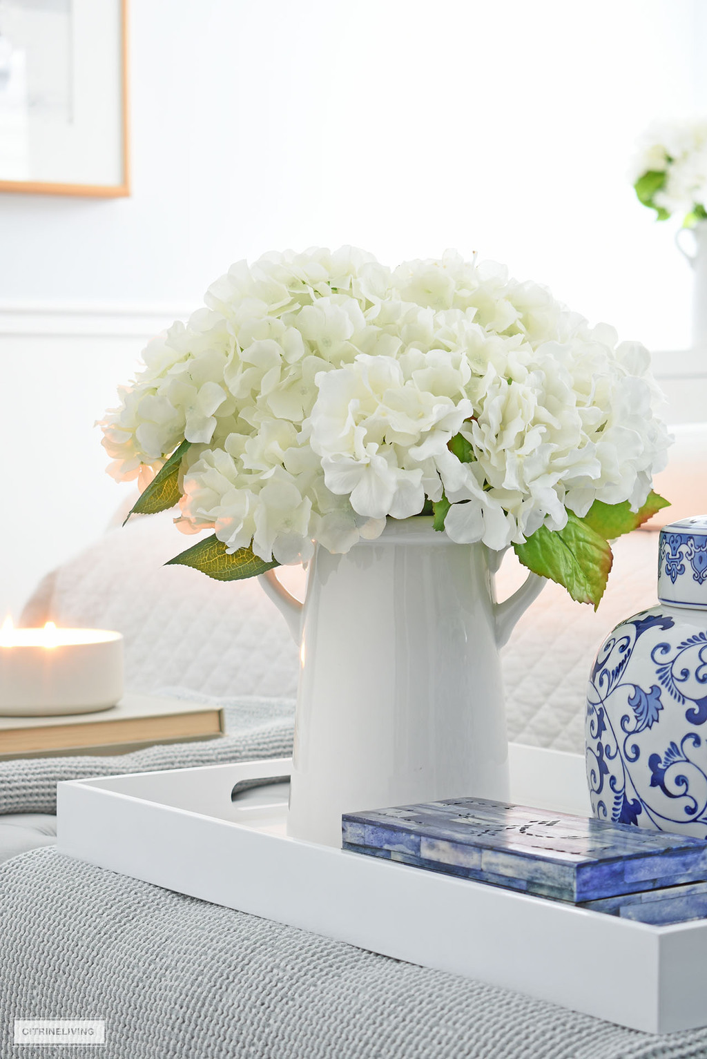 Simple white vase styled with faux hydrangeas is a beautiful bedroom accent.