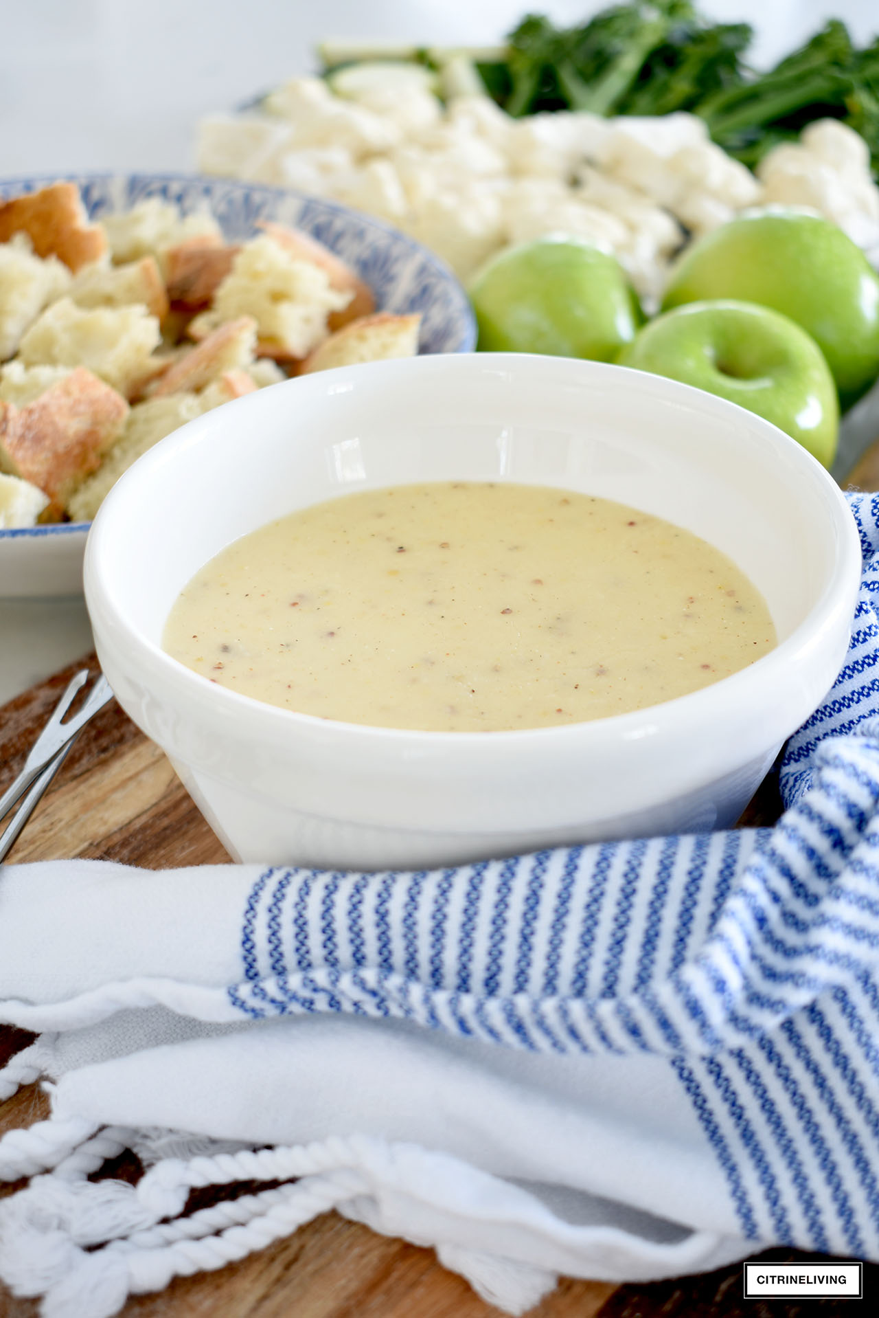 Delicious cheese fondue served with vegetables, bread and fruit.