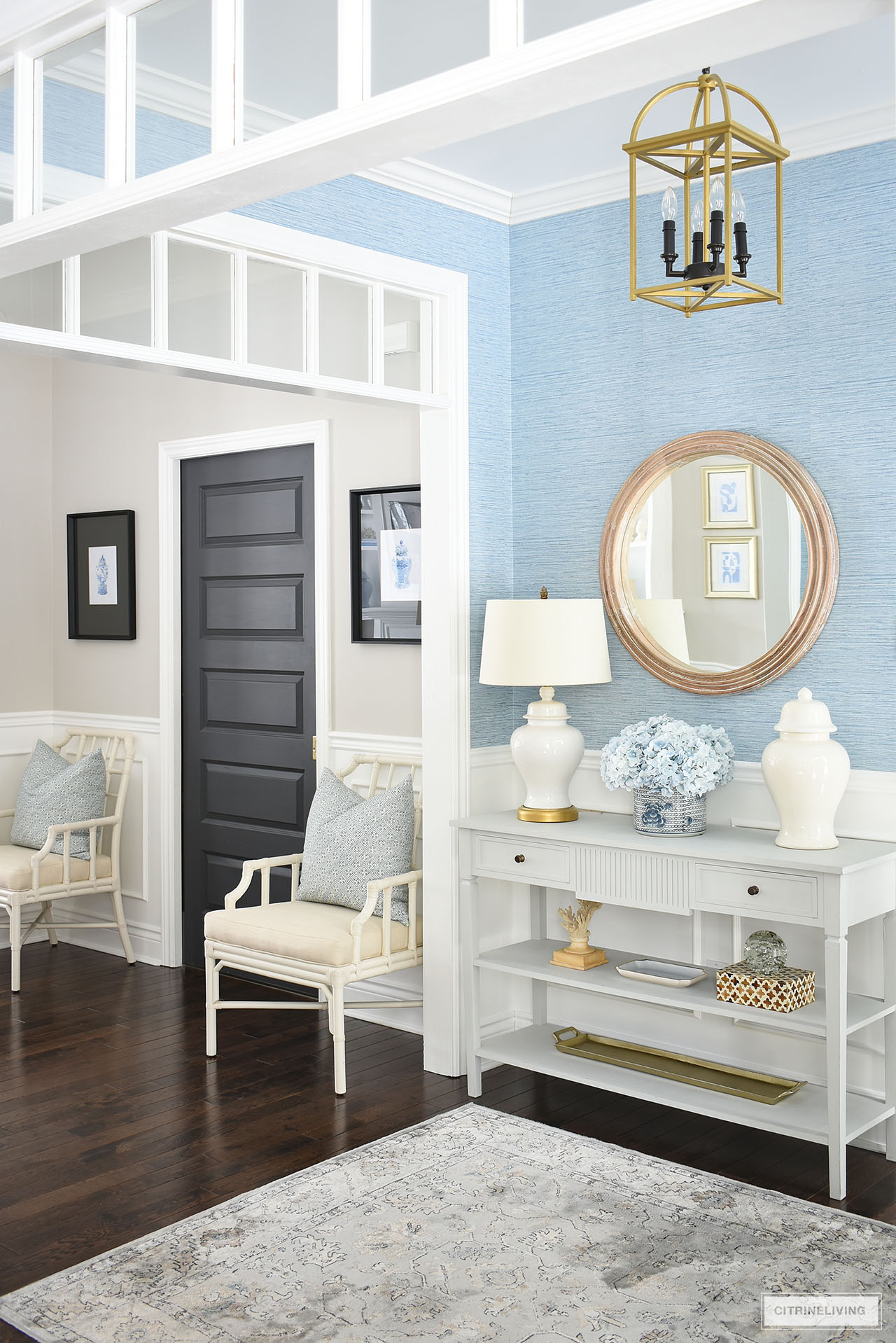 Entryway decorated for spring with a calming color platte using light blue white and natural coloured accessories.