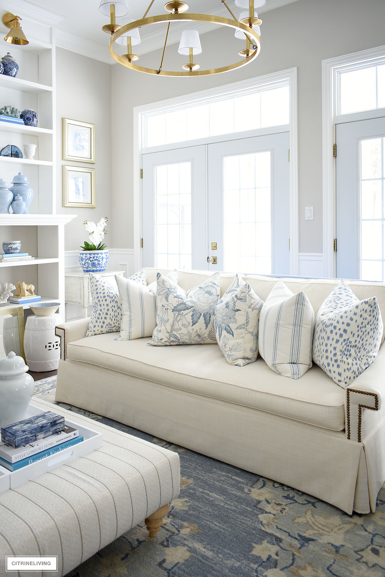 Living room decorated for spring with layers of blue and white decor.