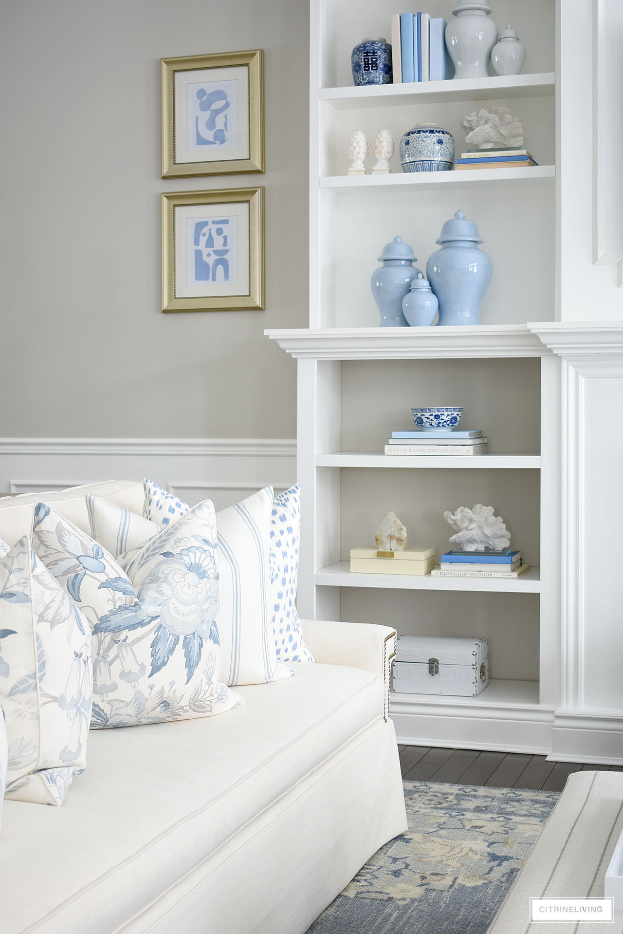 A beautiful collection of ginger jars, decorative books, coral sculptures, bookends and decorative boxes, bowls and planters styled on builtin bookshelves in shades of blue and white is an elegant take on spring decorating.