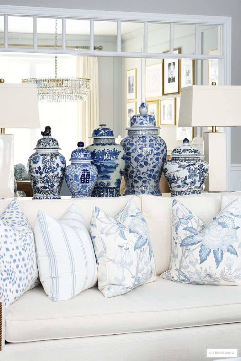 A grouping of blue and white ginger jars behind a living room sofa makes a chic and bold statement!