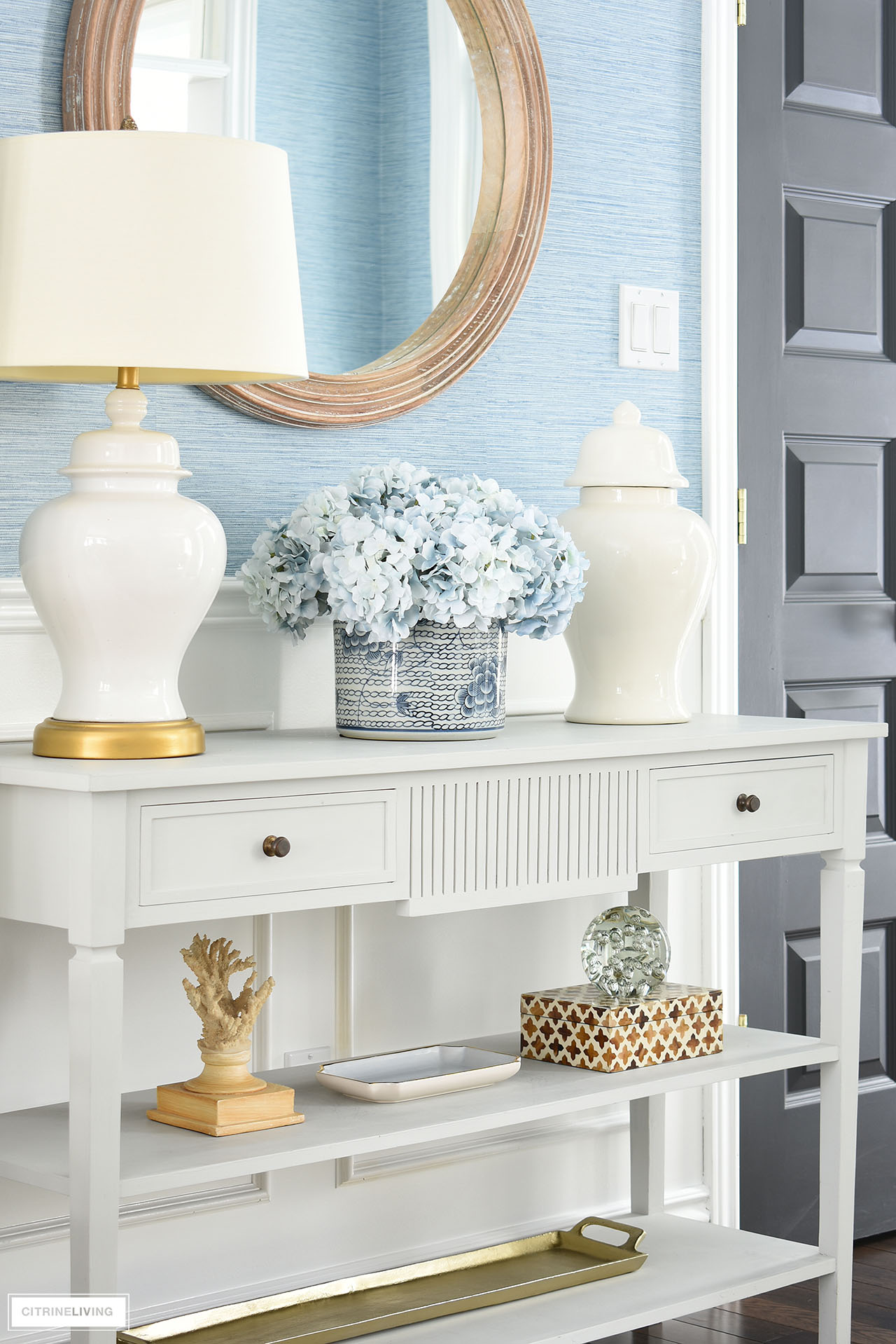 Beautiful entryway spring decor with blue and white accessories styled on a classic console table.