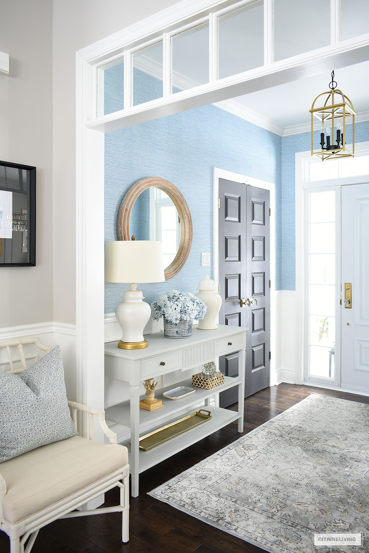 A simply styled spring entryway wth light blue, white and natural accessories.