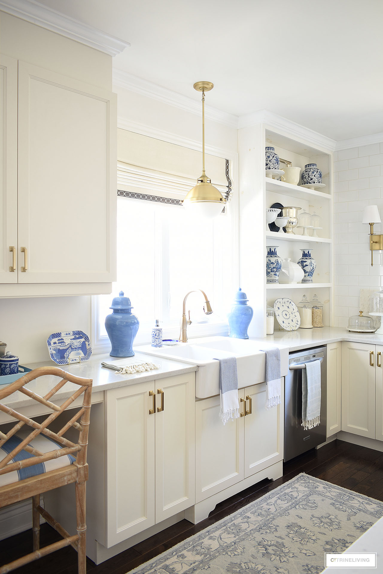 White kitchen farm sink styled with blue ginger jars, blue and white chinoiserie pieces and pretty tea towels.