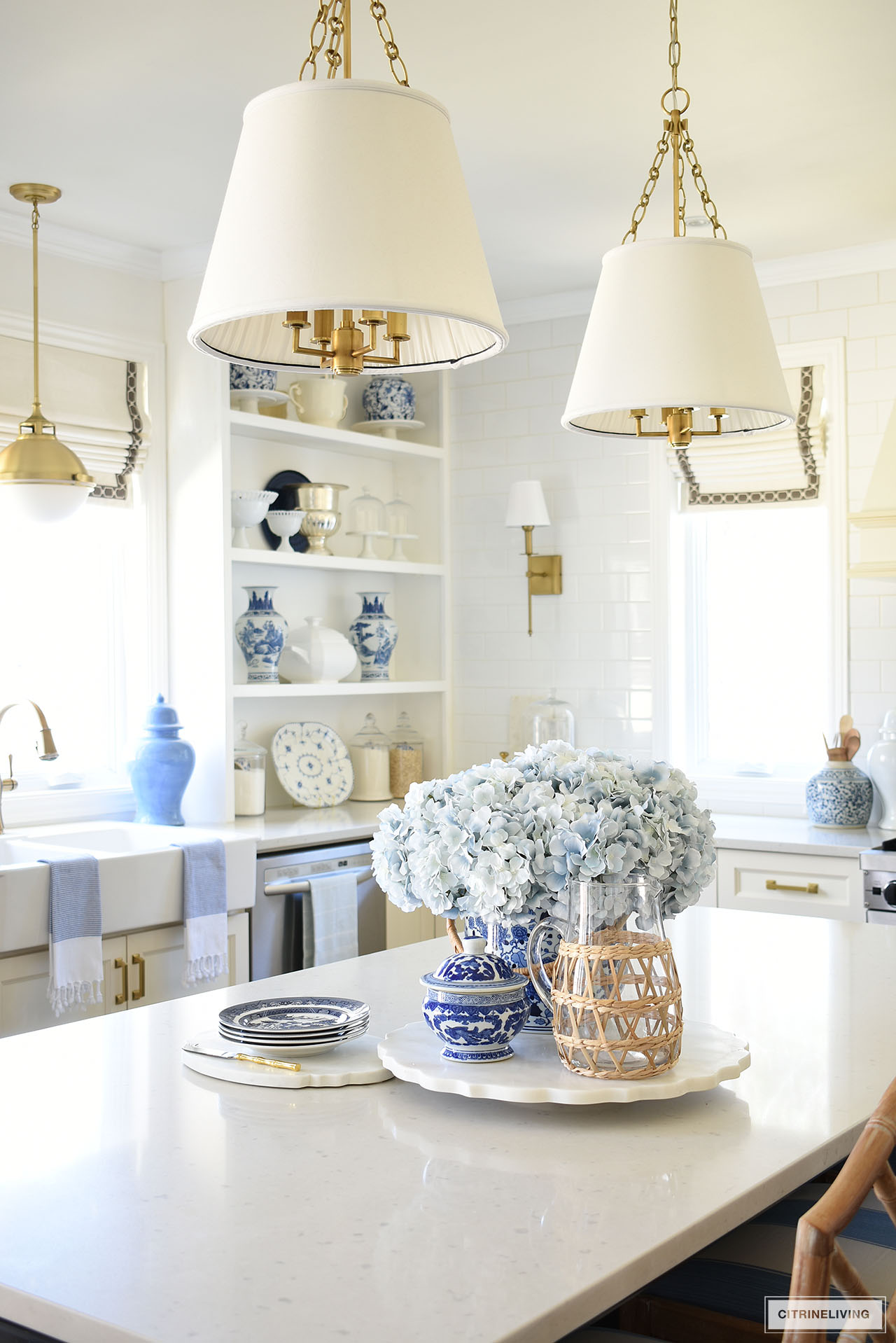 Kitchen island and open shelves styled for spring with beautiful blue and white decor.
