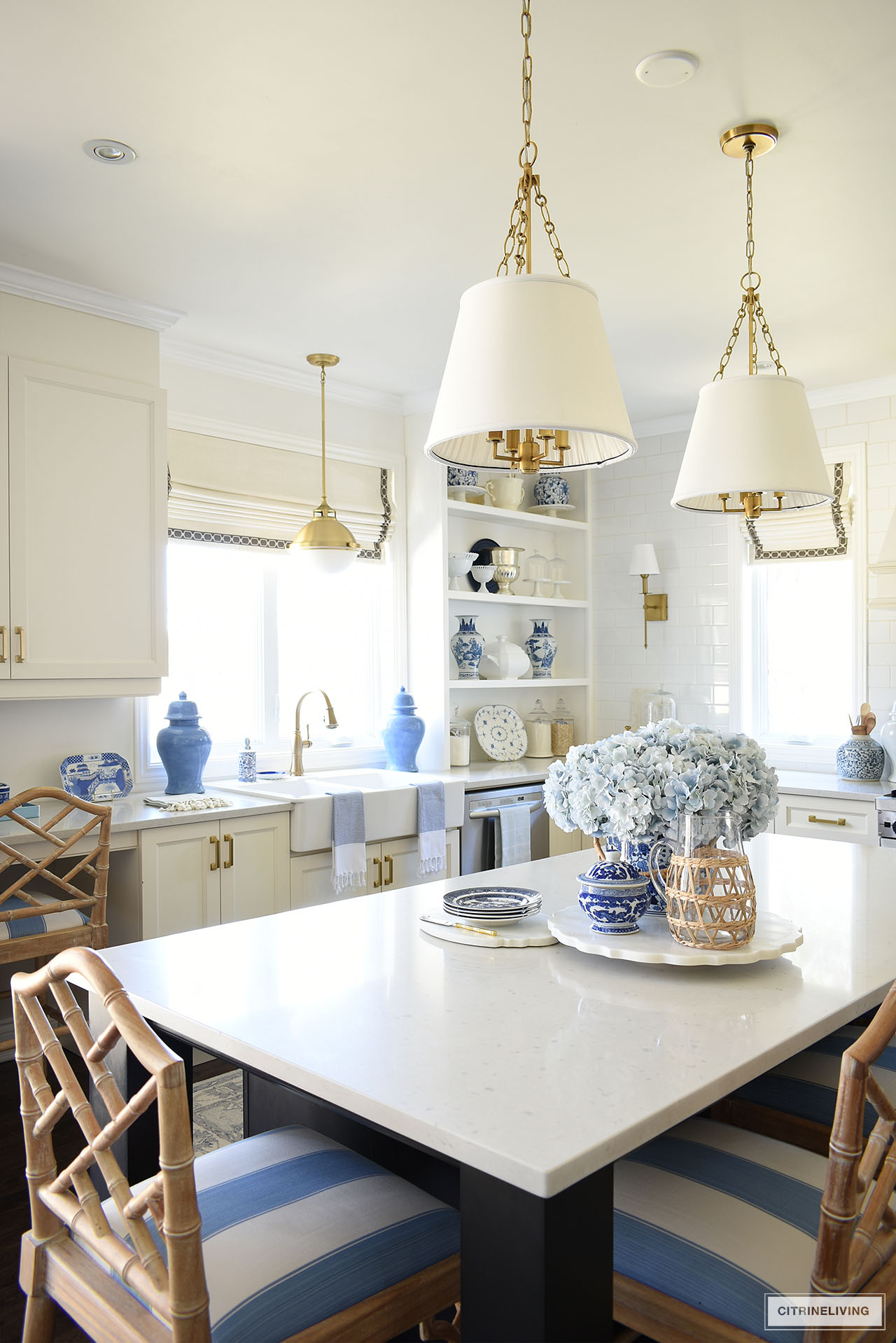 White kitchen decorated for spring with blue and white decor, ginger jars, pretty tea towels and woven accents.