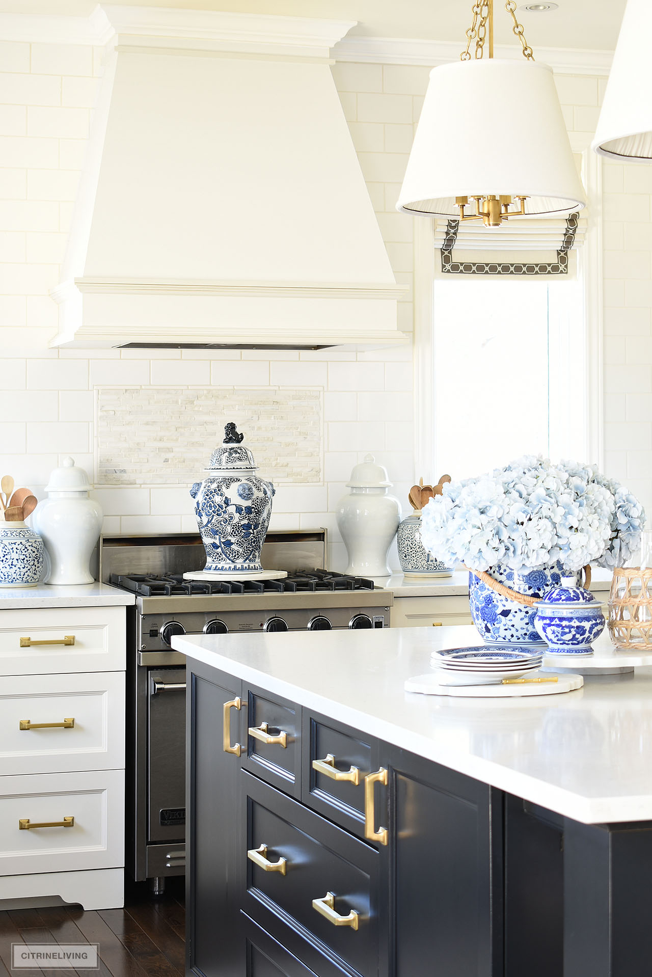Kitchen island and stove styled for spring using beautiful blue and white chinoiserie pieces and faux light blue hydrangeas.