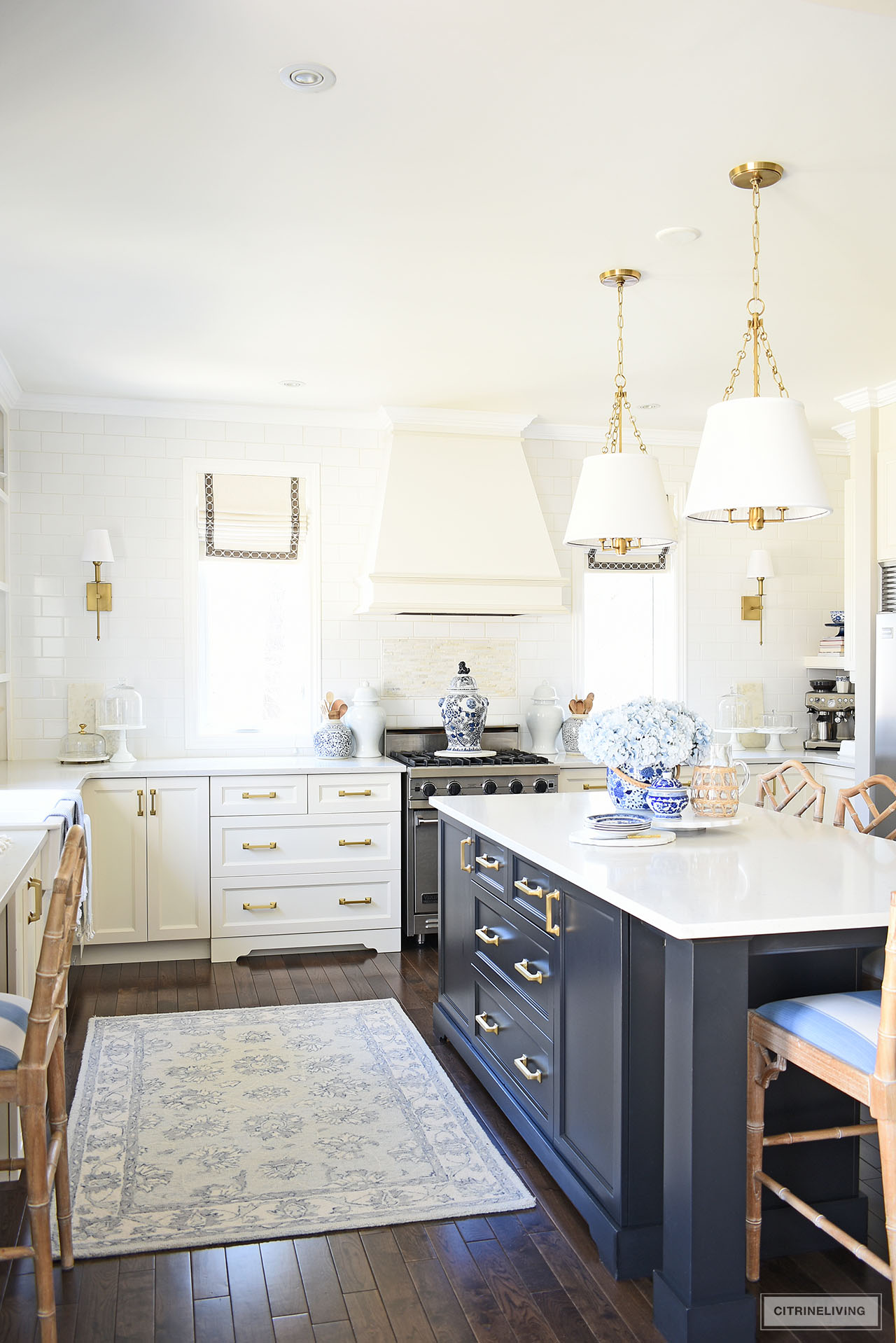 Beautiful white and black kitchen decorated for spring with blue and white accents and faux flowers.