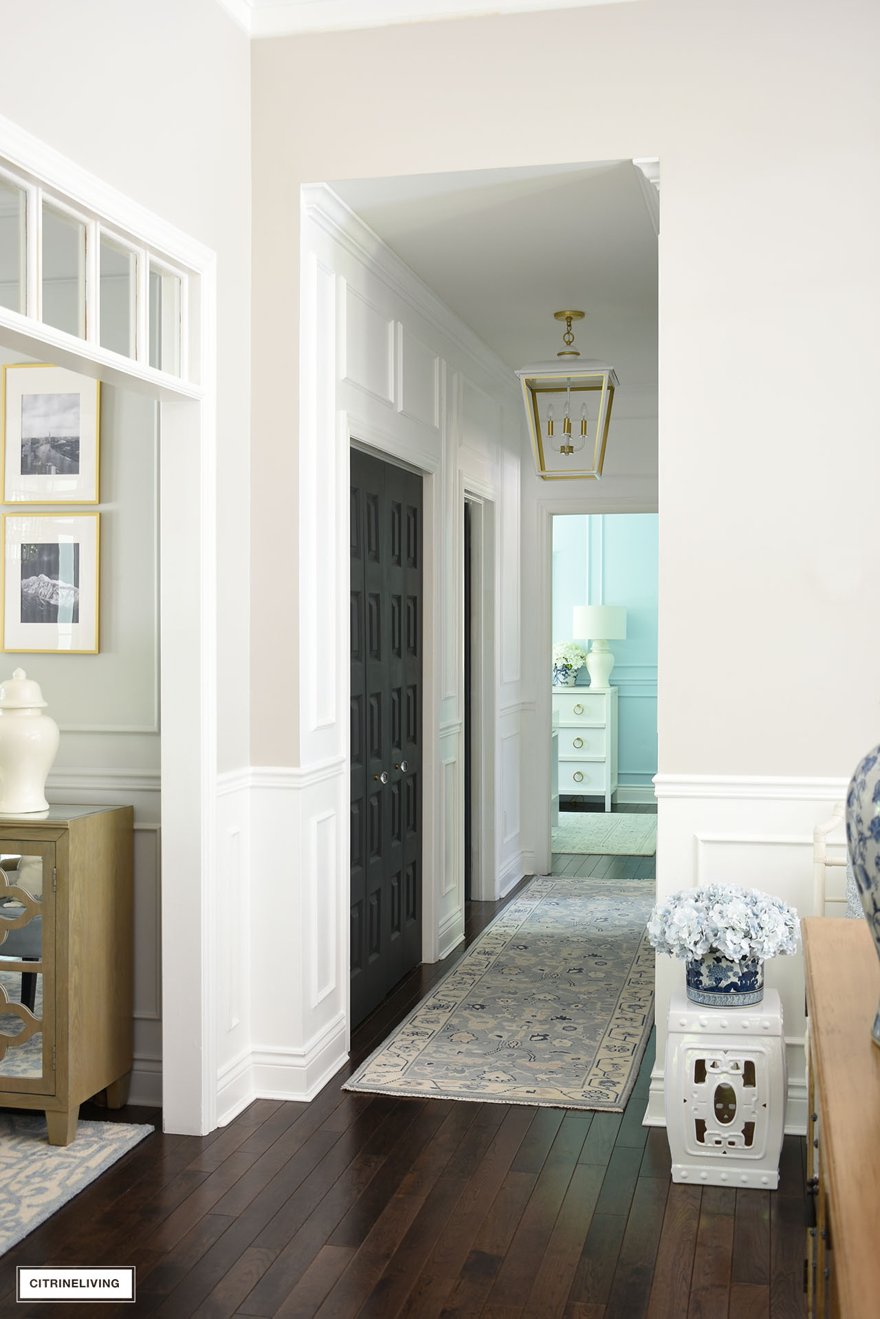 Hallway makeover with fresh white paint, wall moldings, large oversized pendant light and oushak runner