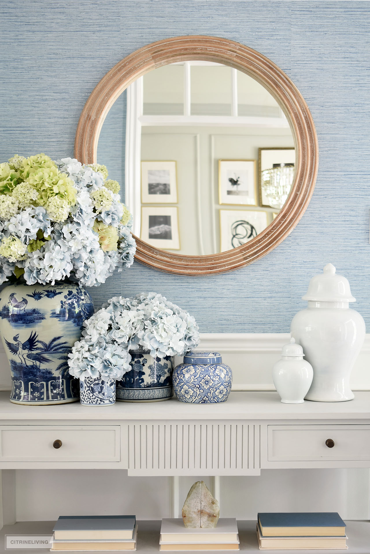 A beautifully styled entryway for summer with blue and white ginger jars and vases arranged with blue and green hydrangeas.