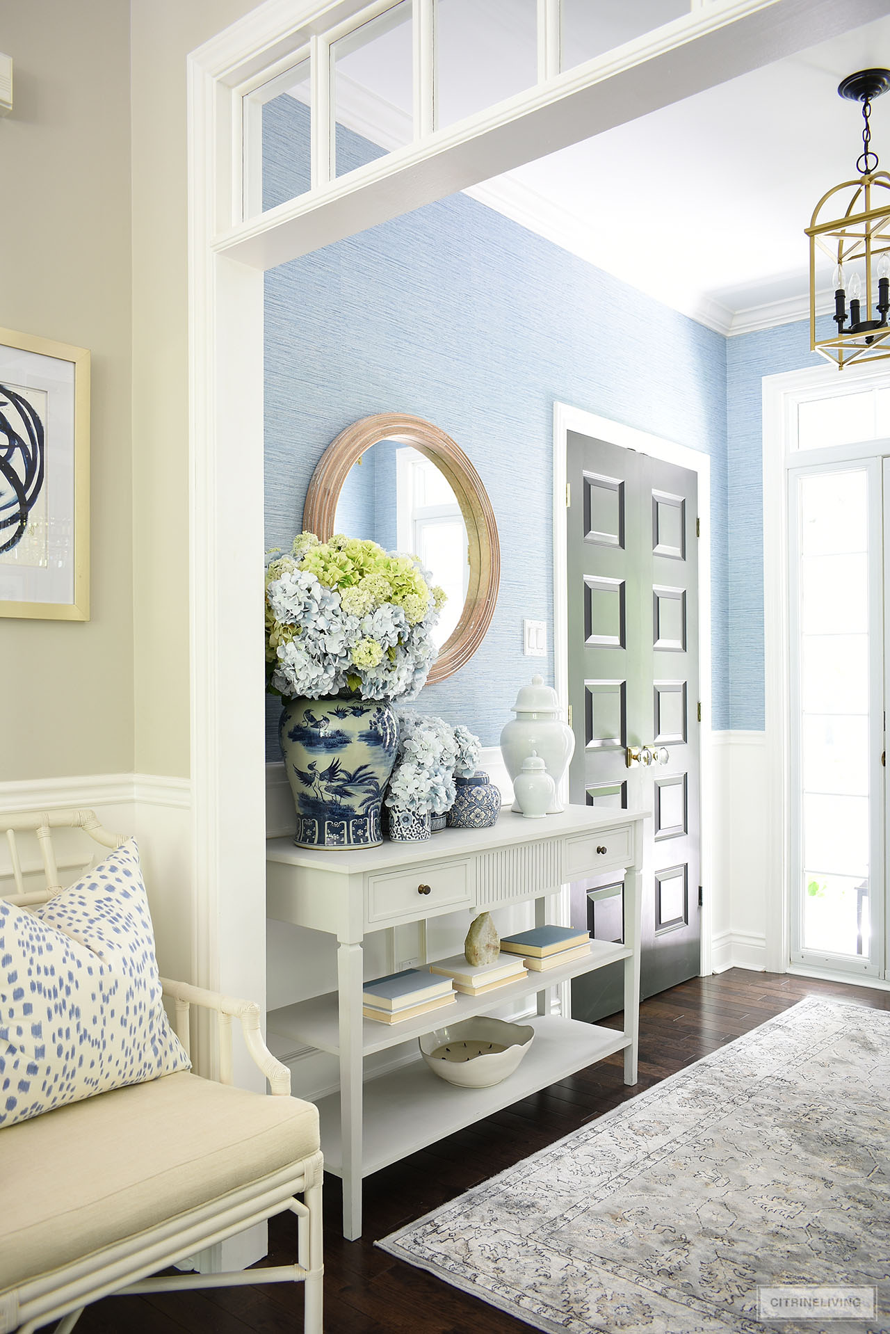 A bright and beautiful summer entryway decorated with blue and white ginger jars styled with gorgeous blue and green hydrangeas and simple accessories.
