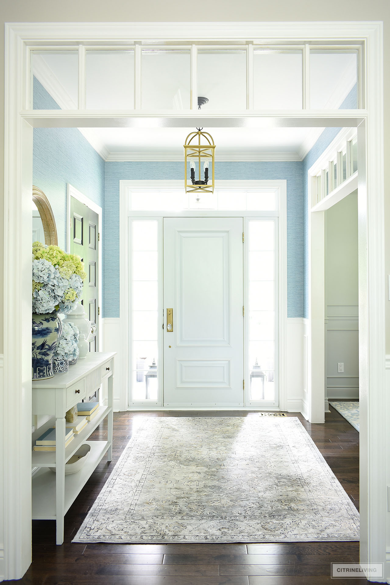 Beautiful light-filled entryway  decorated for summer with classic blue and white and blue and green hydrangeas.