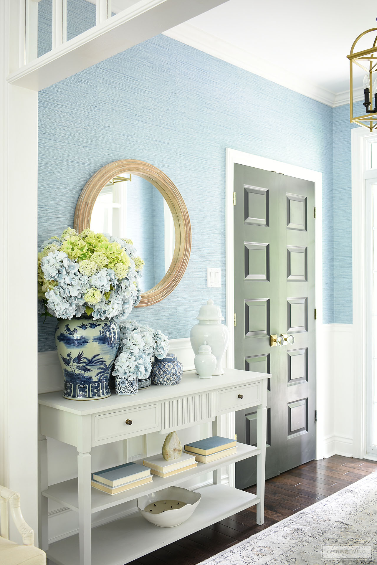 Entryway decorated in blue and white with a beautiful faux hydrangea arrangement in blue and green for summer.