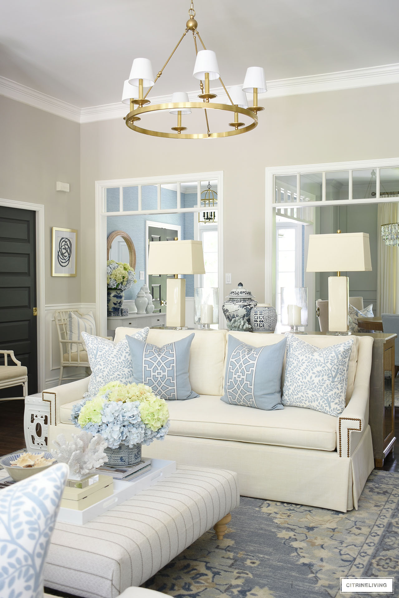 Living room sofa styled for summer with gorgeous designer pillows in soft blue and white.