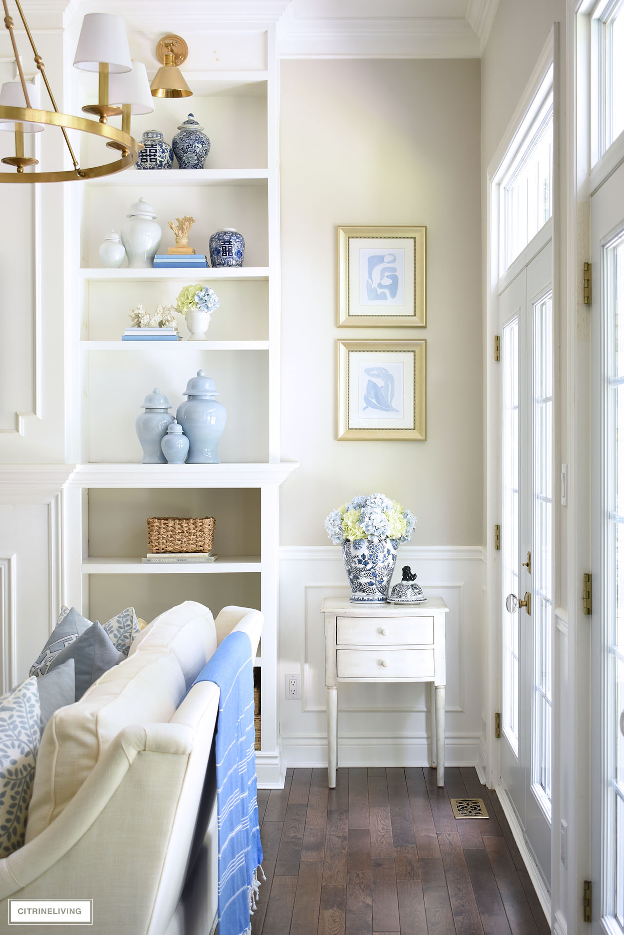 Bookshelves styled for summer with a beautiful blue and white color palette and natural accents.