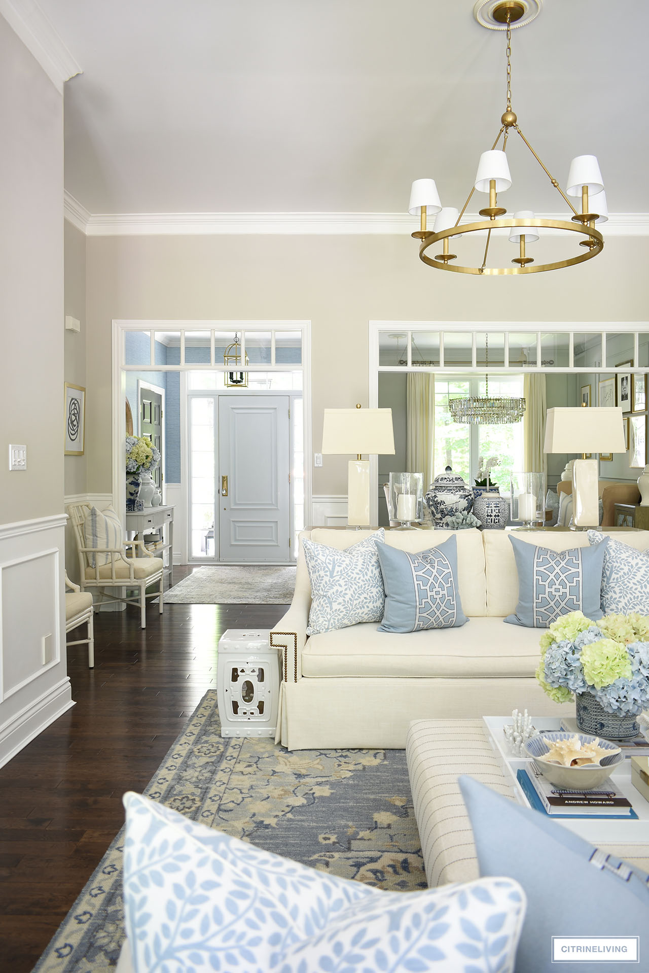 Summer styled living room in soft blues and warm whites with blue and green hydrangeas, chinoiserie accents and coastal accessories.