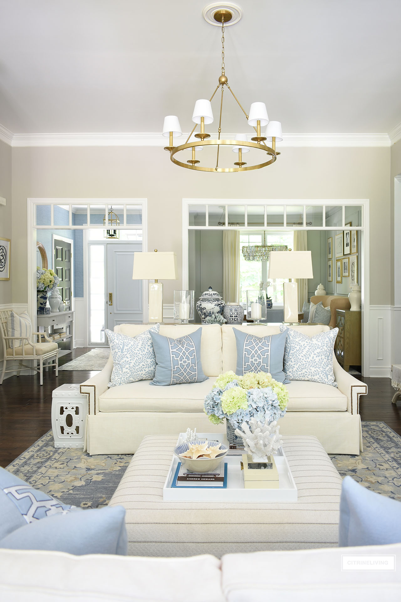 Beautiful and bright traditional living room styled for summer with pretty light blue and green hydrangeas, chinoiserie accents, coastal decor and designer pillows.