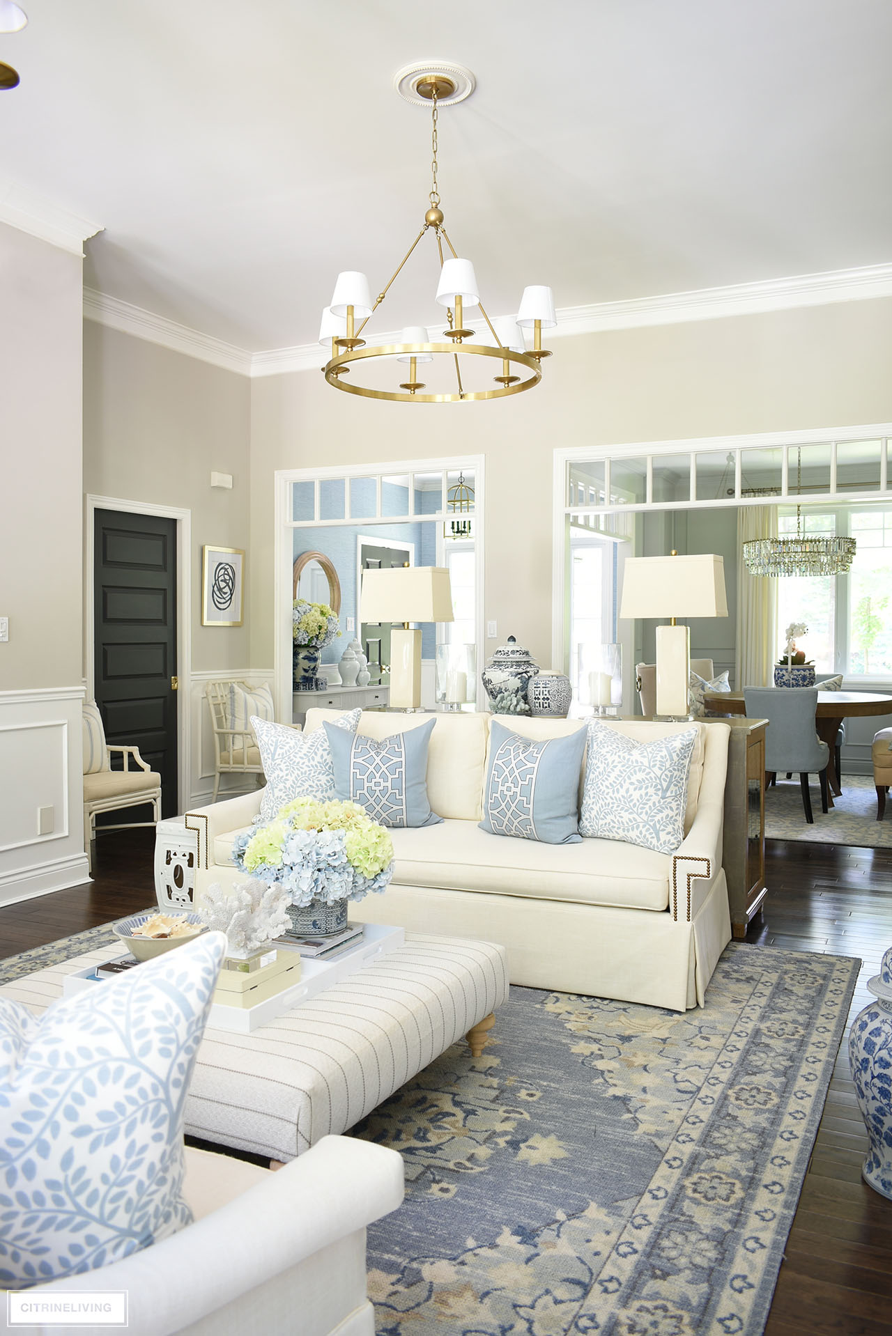 Beautiful living room decorated for summer in blue and white with faux hydrangeas, ginger jars and coastal touches.