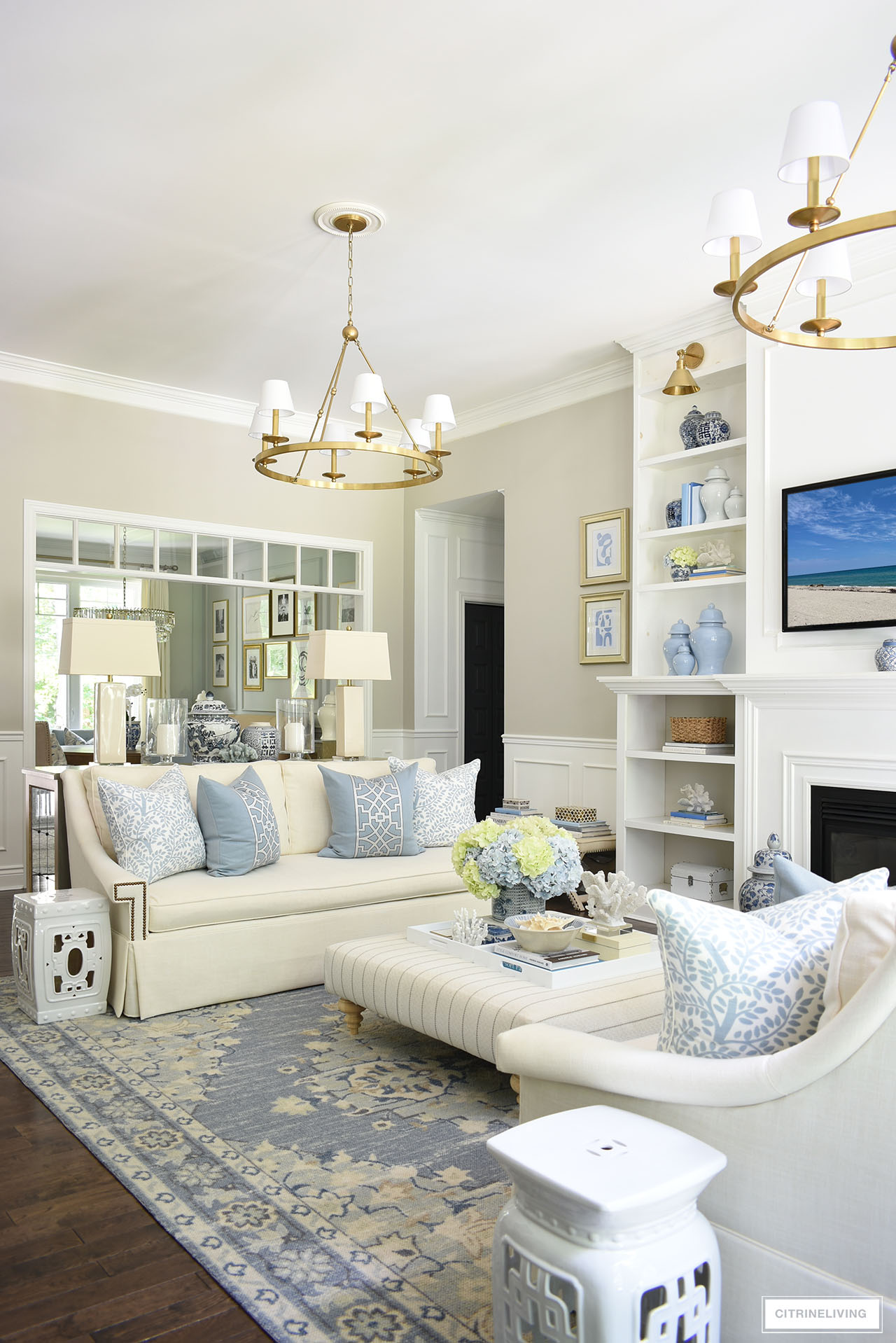 Beautiful living room decorated for summer with soft blues, warm whites, light green and blue hydrangeas and coastal accents.