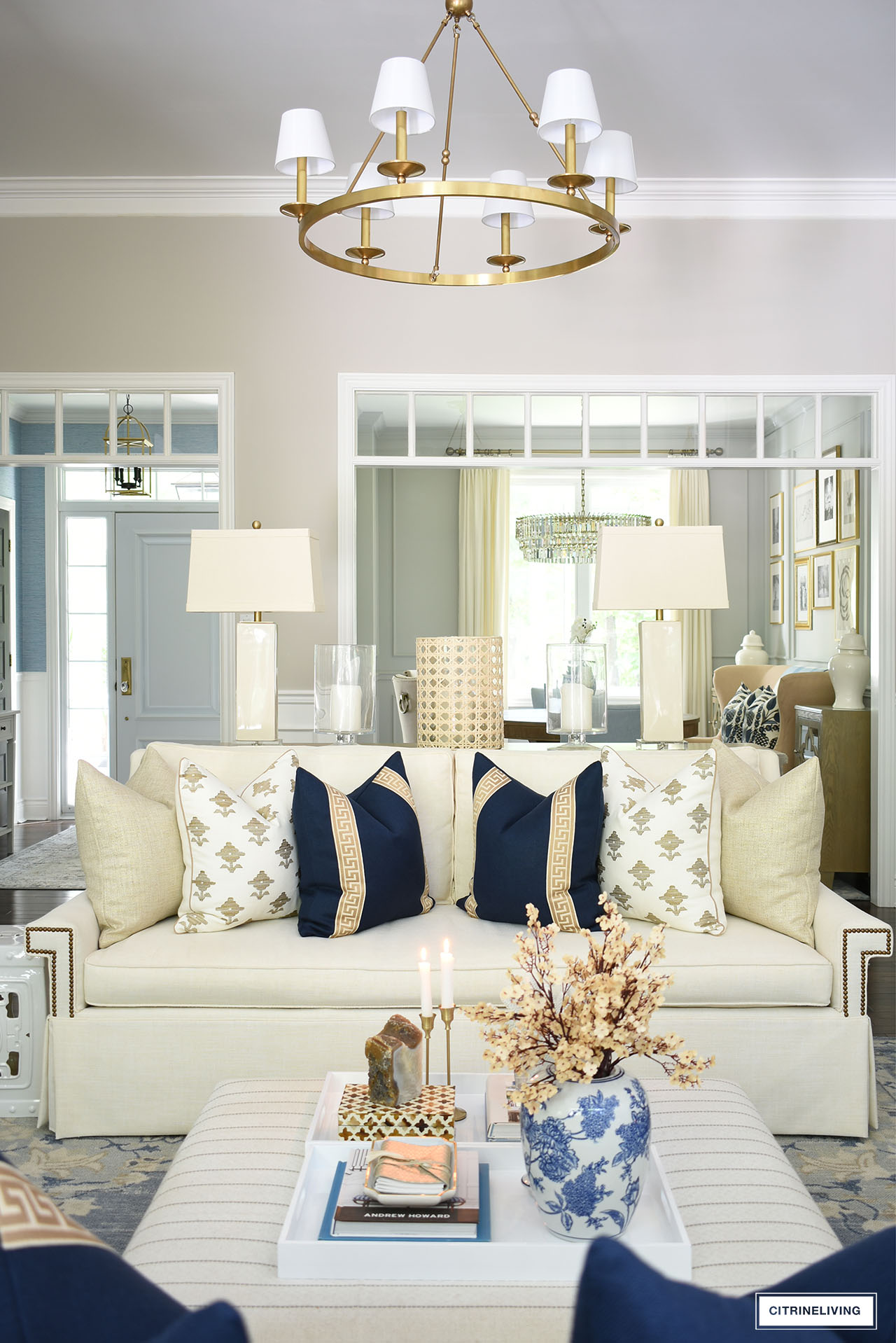 Chic and elegant fall decor layered with navy, tan and gold pillows for a cozy but sophisticated look.