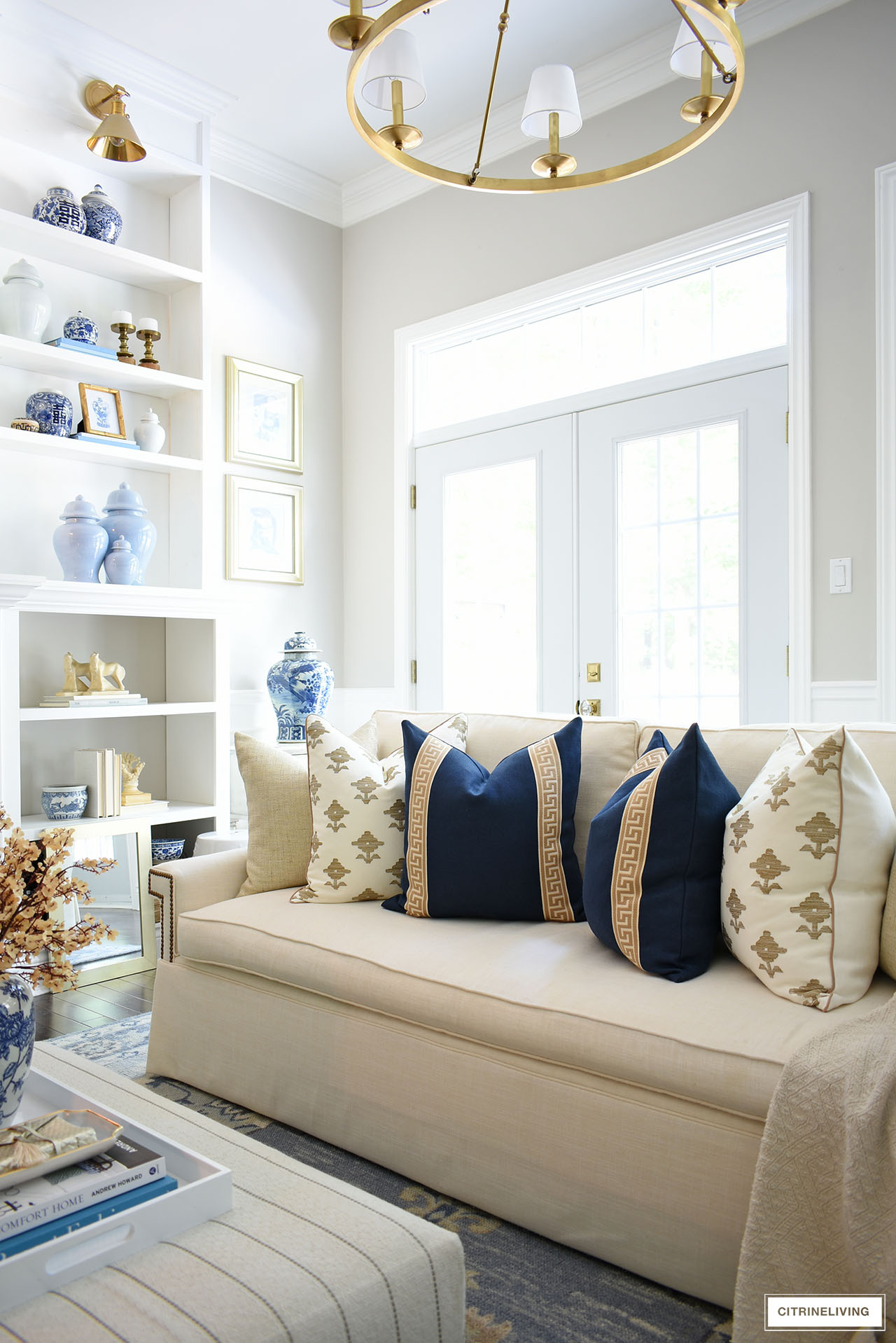Pillows in navy, tan, white and gold styled for fall in this elegant and cozy living room.