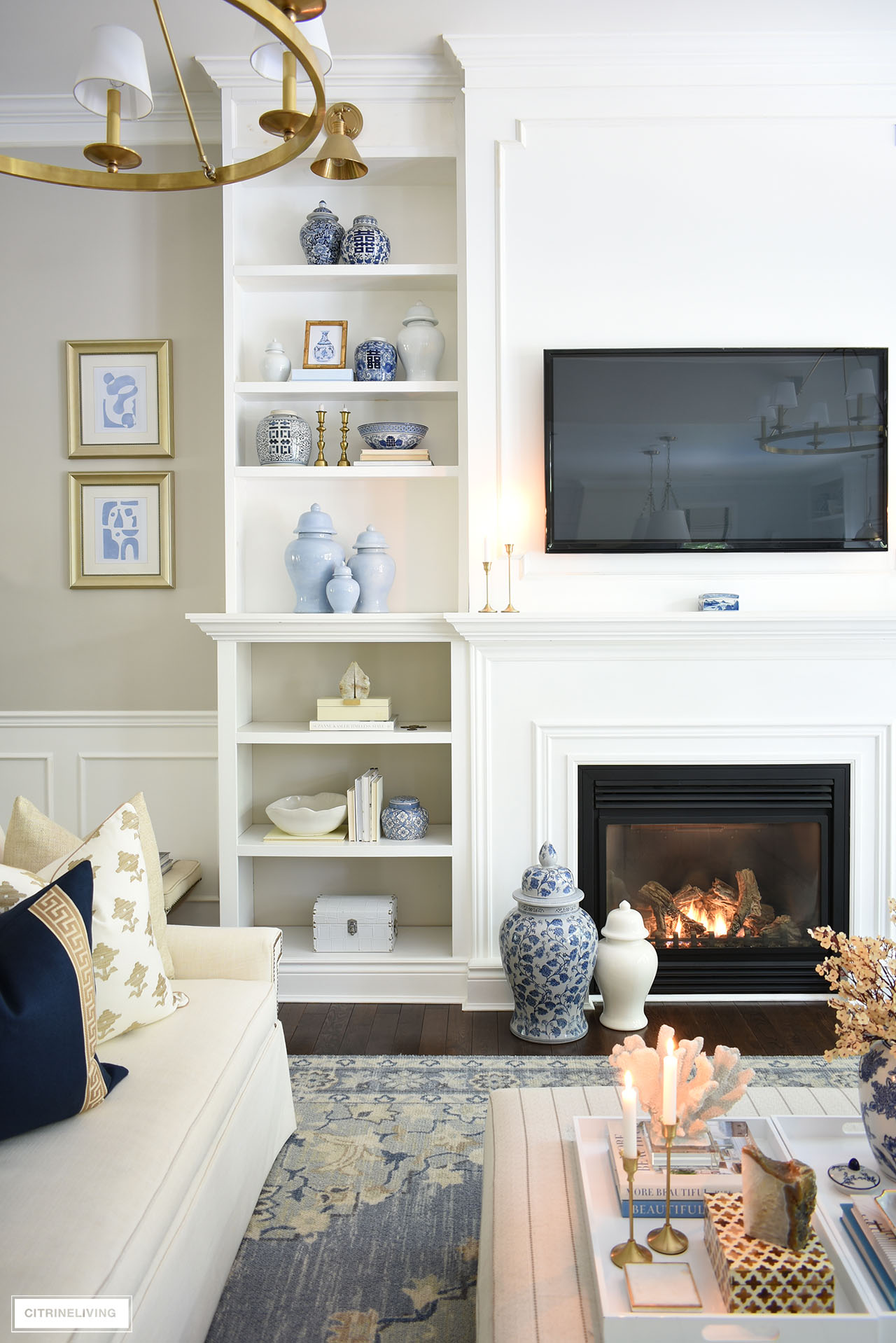 Living room bookshelves decorated for fall with blue, gold, white and natural elements.