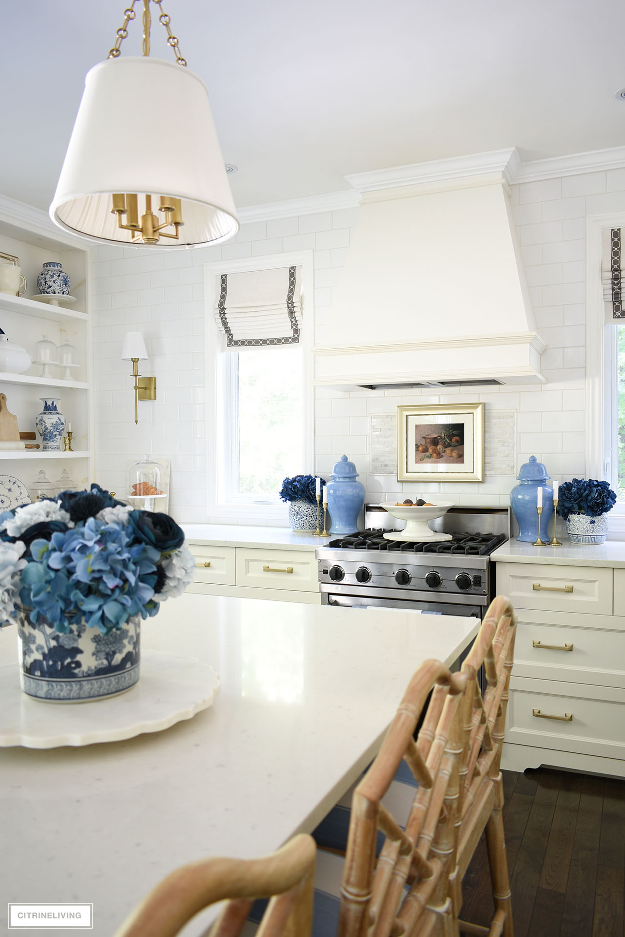 Traditional kitchen decorated for fall with vintage framed art, blue florals and gold accents.