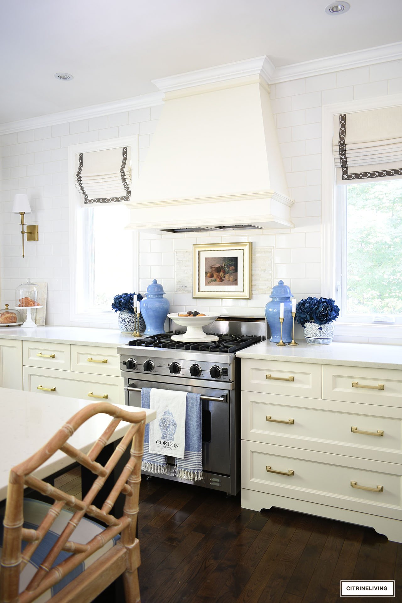 Kitchen stove decorated for fall with navy florals, dark blue ginger jars, vintage art and gold candlesticks.