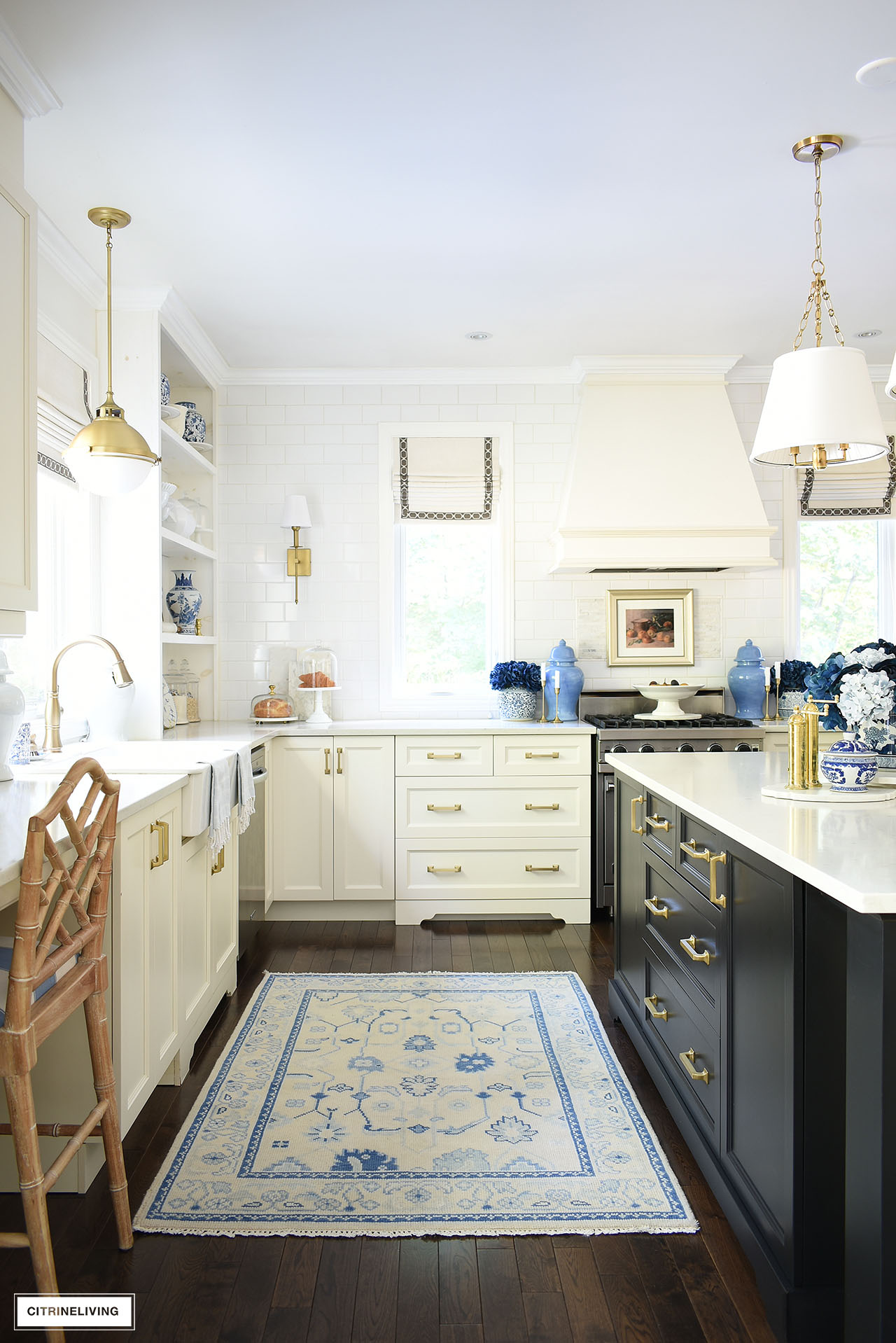 Kitchen decorated for fall with a blue and ivory oushak rug, blue floral arrangements, vintage art and gold accents.