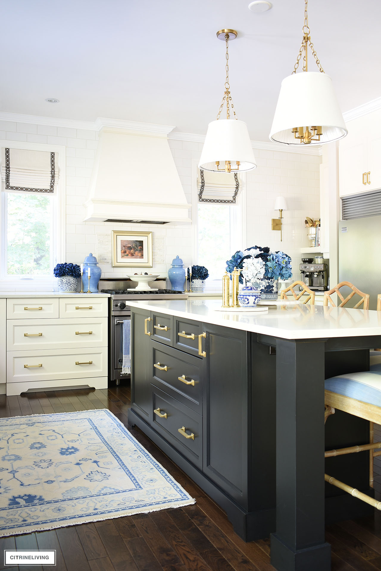 Kitchen decorated for fall with layers of blues, gold, vintage art, oushak rug and natural elements.
