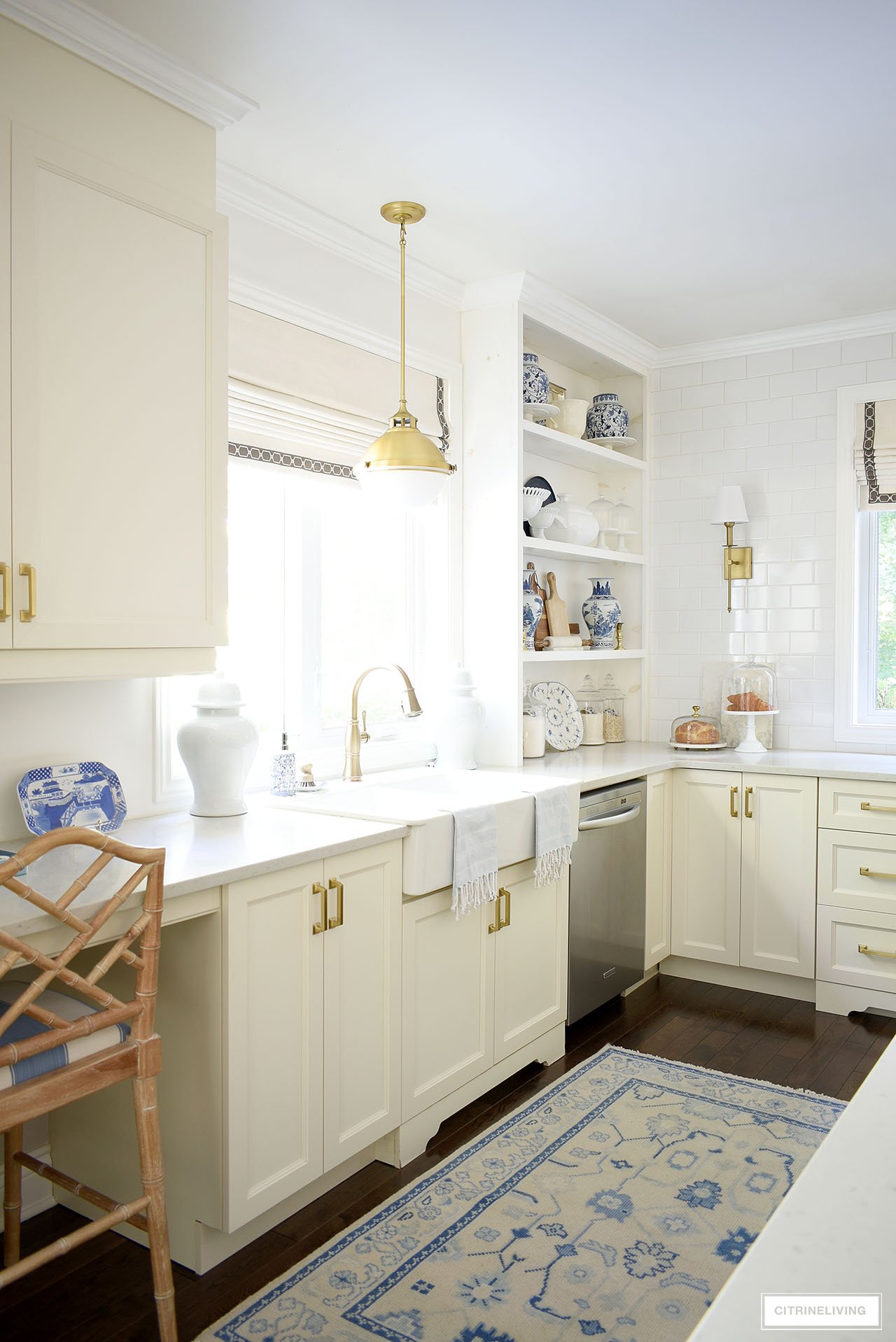 Elegant fall kitchen decorated with simple blue and white touches, a beautiful oushak rug and natural elements like wood cutting boards and baked goods.