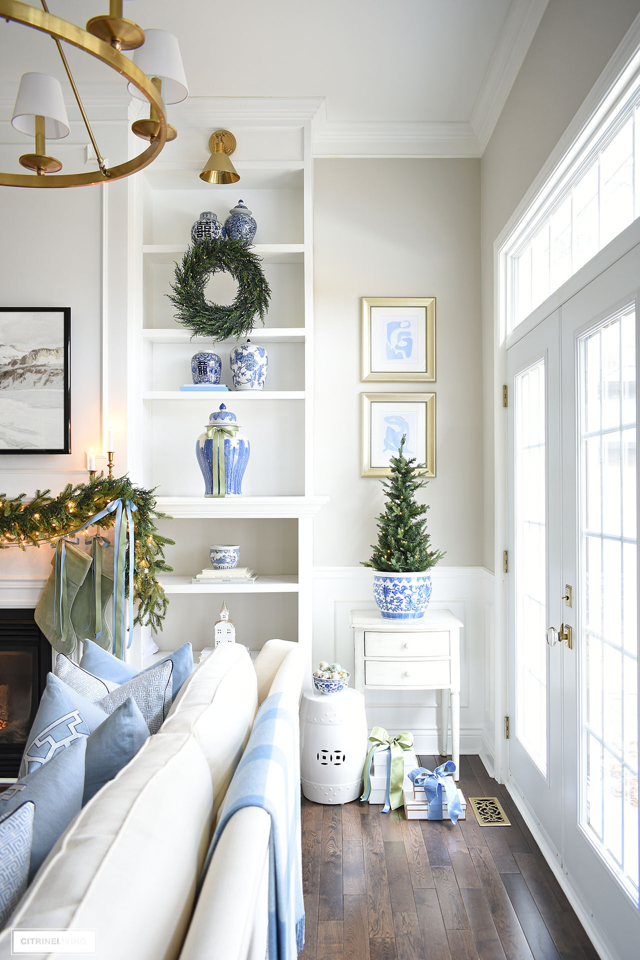 Blue and white chioiserie, Christmas garland, ginger jars, planters and simple Christmas decor on white painted bookshelves.