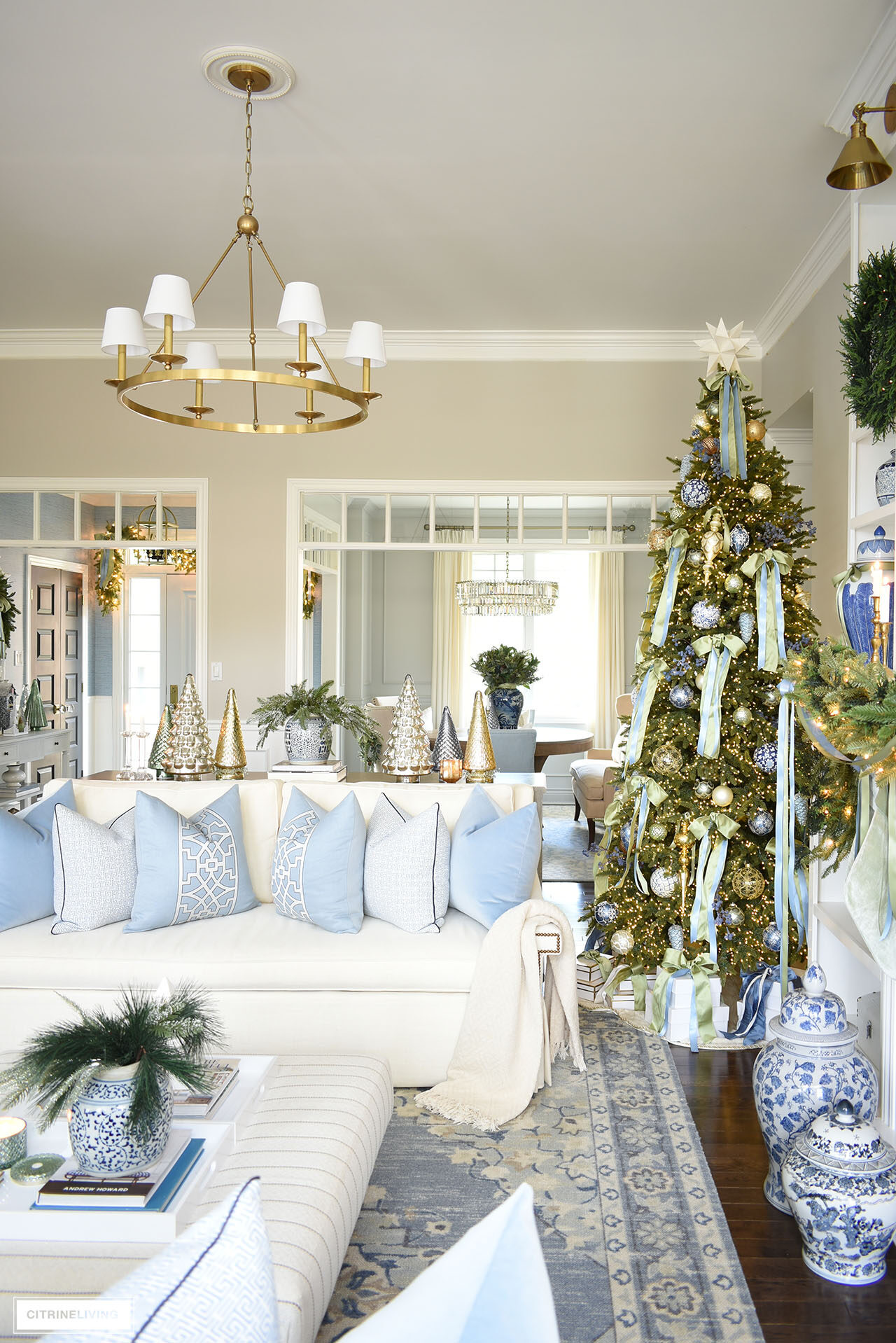 Beautiful Christmas decorated living room , white sofa with blue pillows, Christmas tree with light green and blue bows.