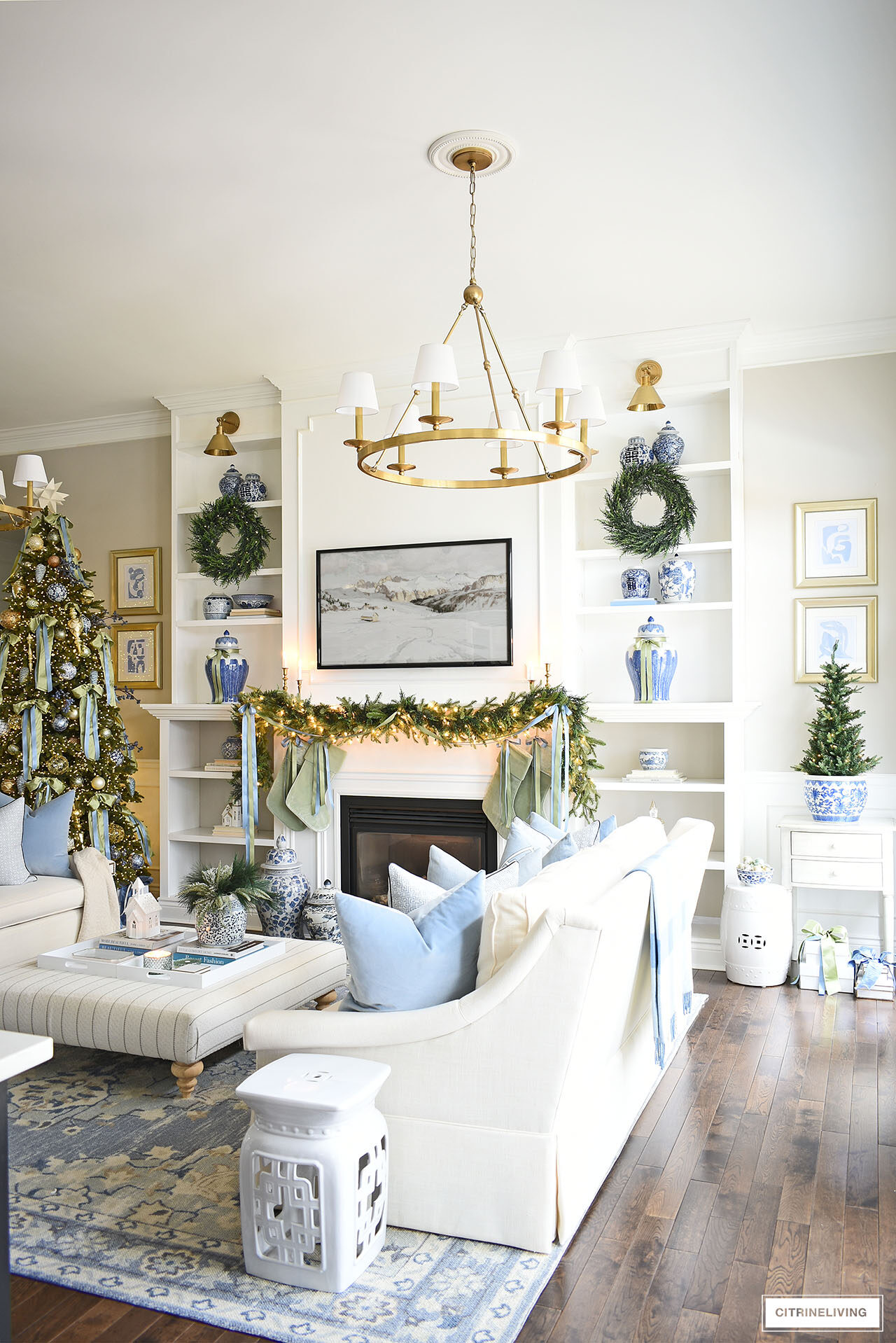 Beautiful floor to ceiling shelves and fireplace decorated for Christmas with green garland and wreaths.