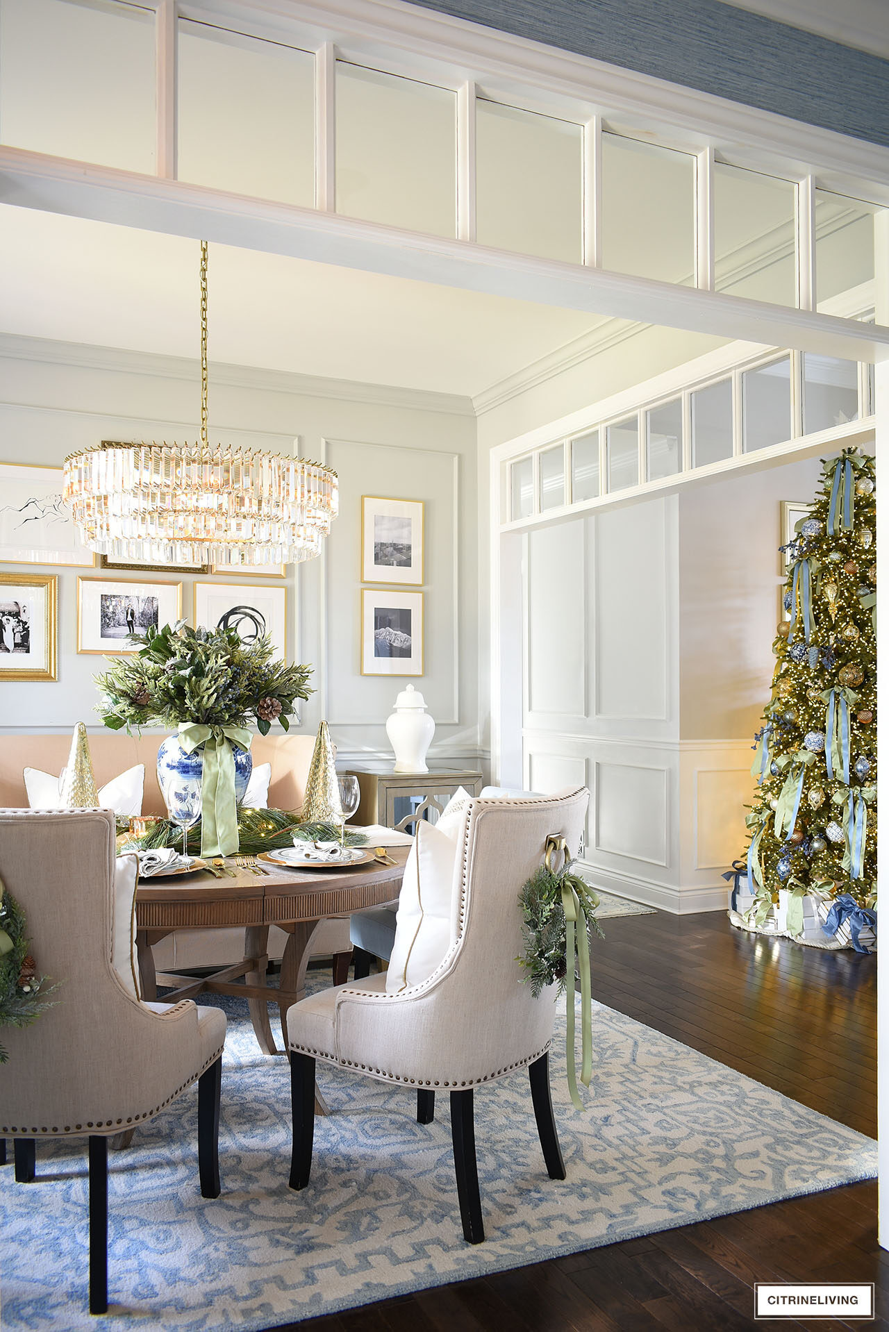 Christmas dining room with greenery accents and a view of the Christmas tree in the next room