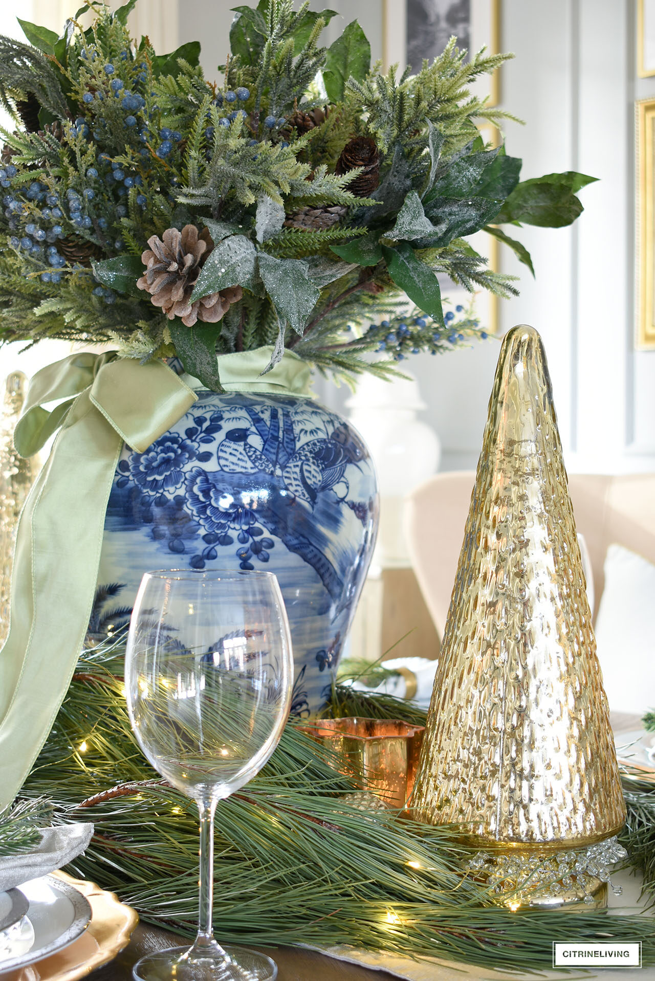 Beautiful details of a christmas table setting with mercury glass christmas tree and fresh pine branches