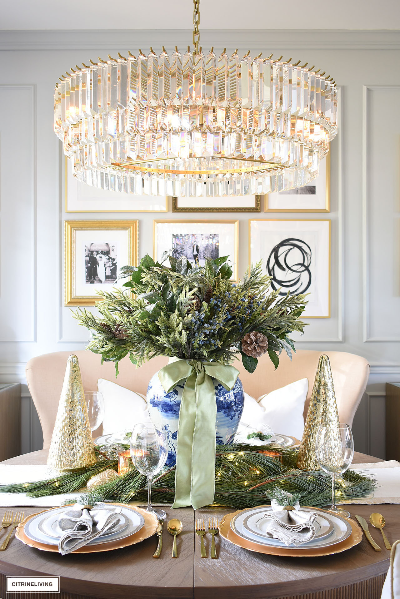 Christmas centerpiece with holiday greenery and blue and white ginger jar, silver and gold dishes